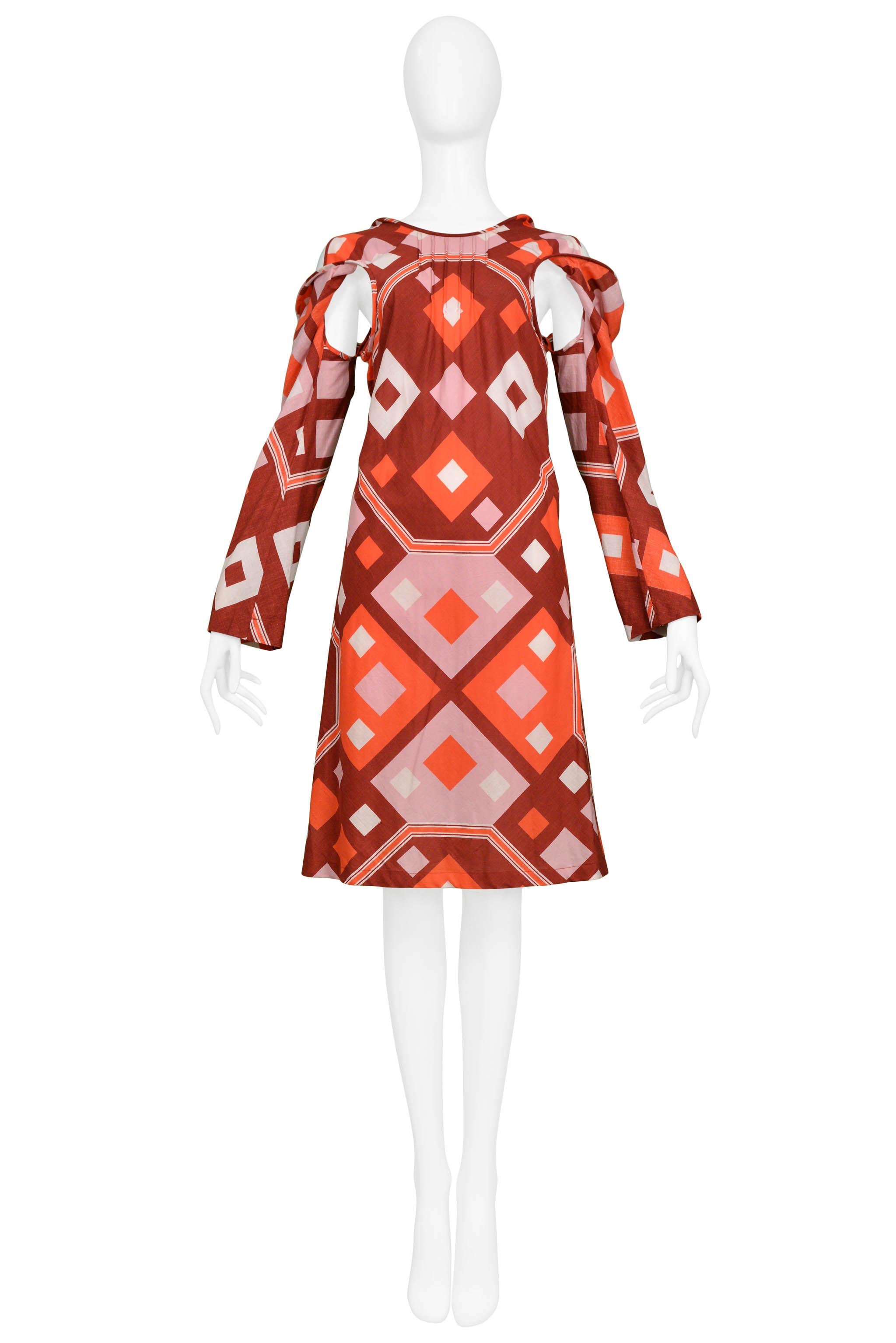 Resurrection Vintage a le plaisir de vous proposer une robe de jour vintage Junya Watanabe for Comme des Garcons en coton rose, rouge et orange avec un imprimé déco, des découpes sous les bras et des manches longues. Collection SS 2003.

Junya