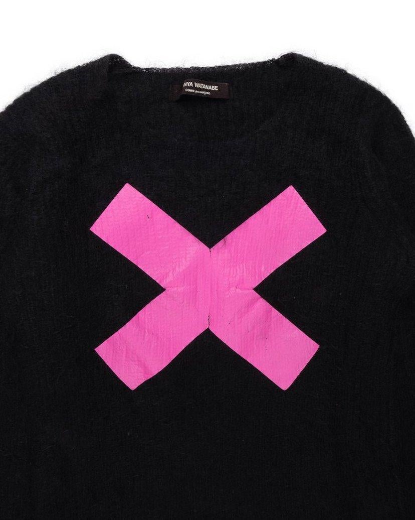 This wool and nylon blend sweater comes from the early days of Junya Watanabe’s label, and features a large “X” printed atop the chest. Although it predates his men’s line, it features an oversized, unisex cut.

Condition: 8/10. Some cracking along