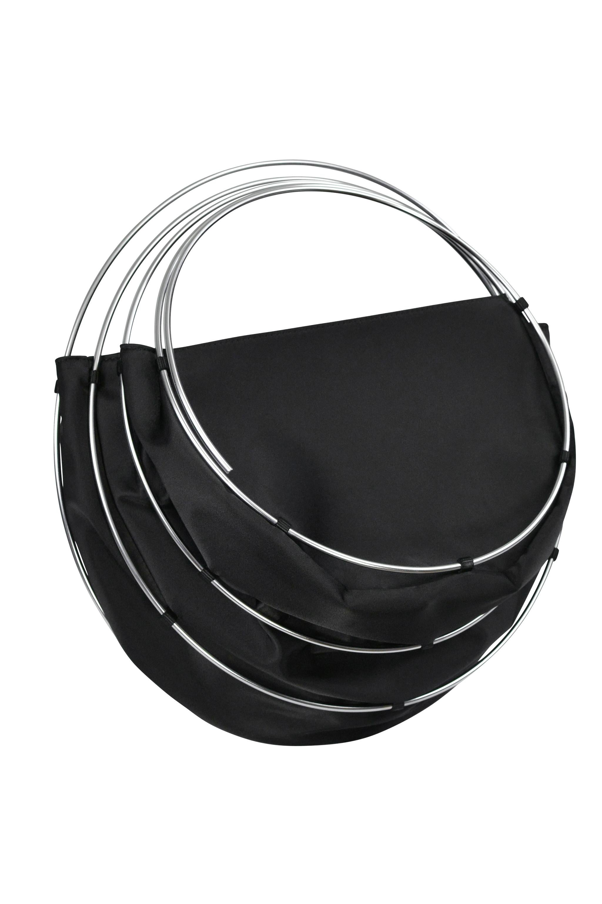 Resurrection Vintage se complace en ofrecer un bolso jaula vintage Junya Watanabe negro con anillas metálicas de la colección de 1999, con un diseño plegable, asas metálicas en espiral y cremallera y bolsillo interiores. 

Junya Watanabe
1999