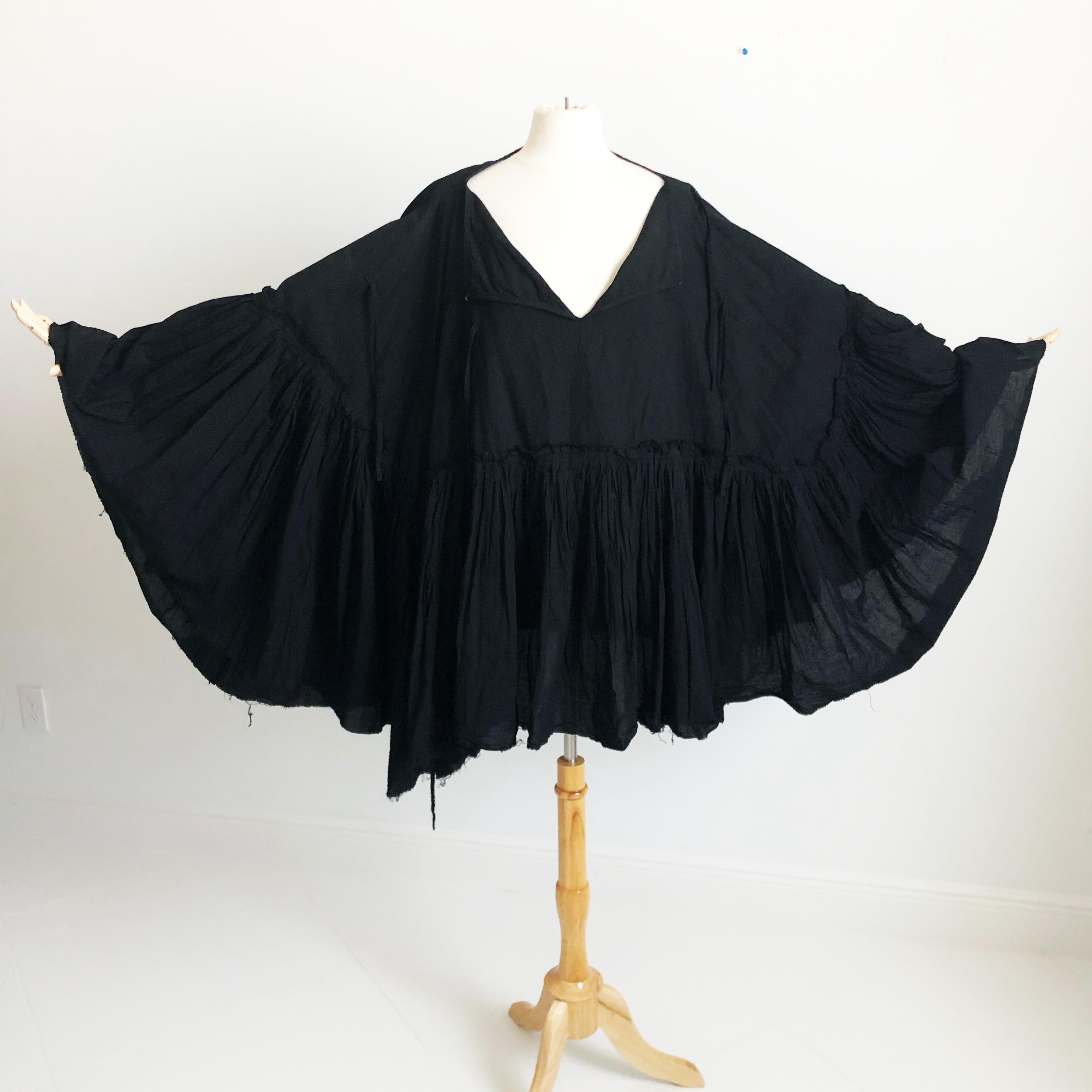 Authentic, preowned Junya Watanabe Comme de Garcons black cotton ruffle poncho, tagged size M. Hard to find style. Massive amount of cotton fabric & features several ties enabling a variety of looks with hook/eye closure at neckline. 

A chic