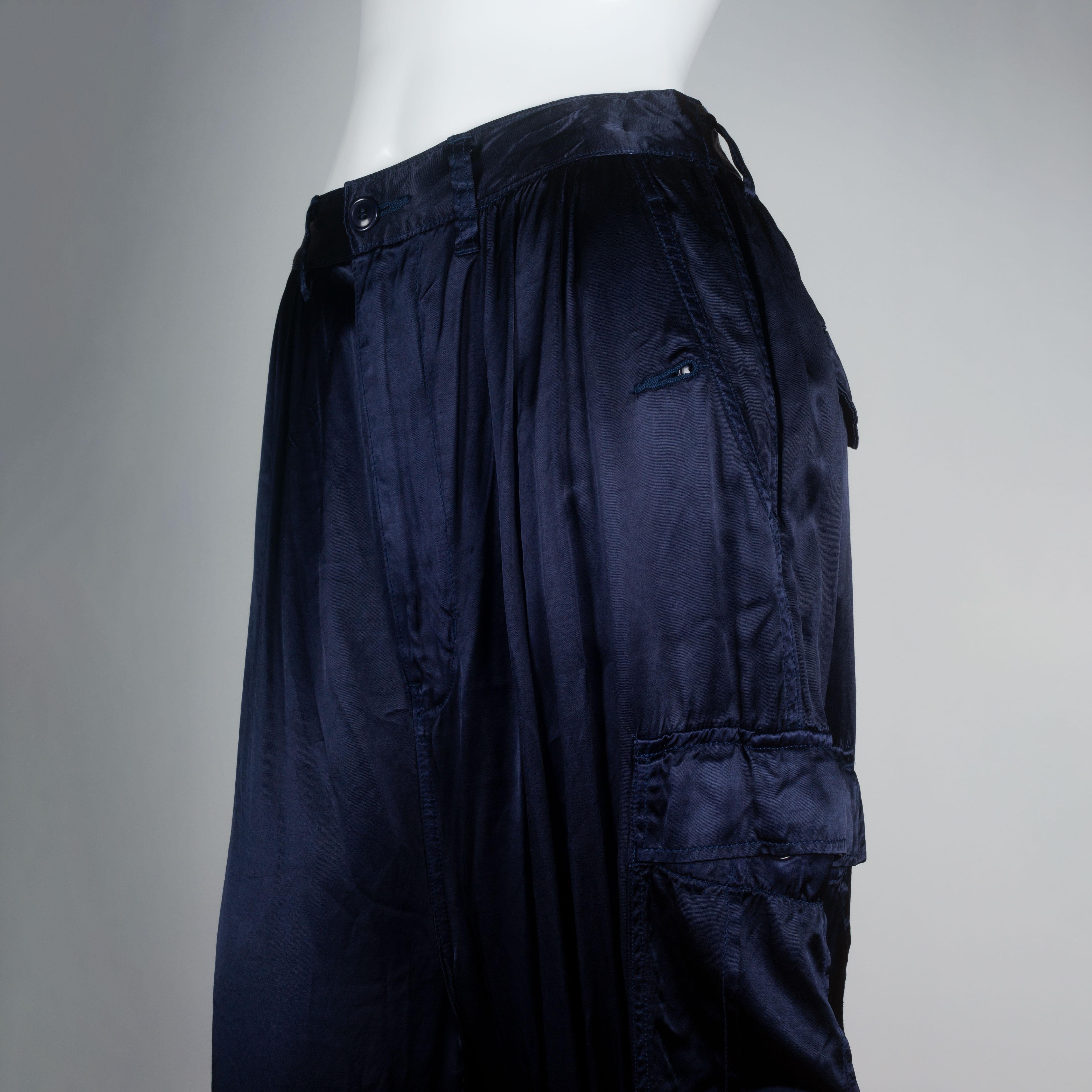 Junya Watanabe Comme des Garçons dark blue satin cargo pants from Japan. A utilitarian style, combined with a flashy material. Draw strings around hem, button cargo pockets and button on hip pockets complete the design.  