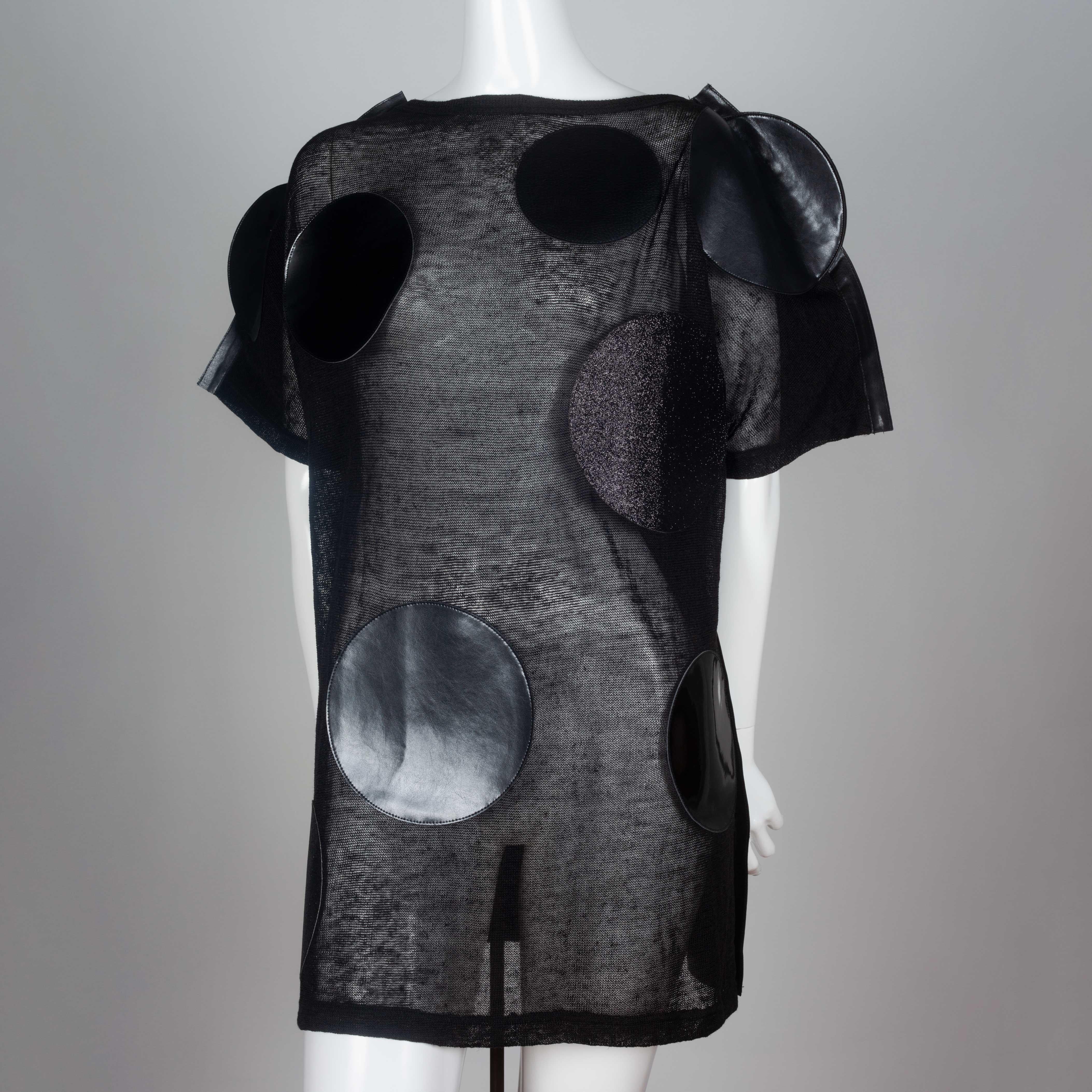 Junya Watanabe Comme des Garçons 2014 oversized sheer linen and synthetic leather dress embellished with faux leather circles. The back in entirely synthetic leather contrasts the front circle design.
 
YEAR: 2014
MARKED SIZE: S
US WOMEN'S: S
US