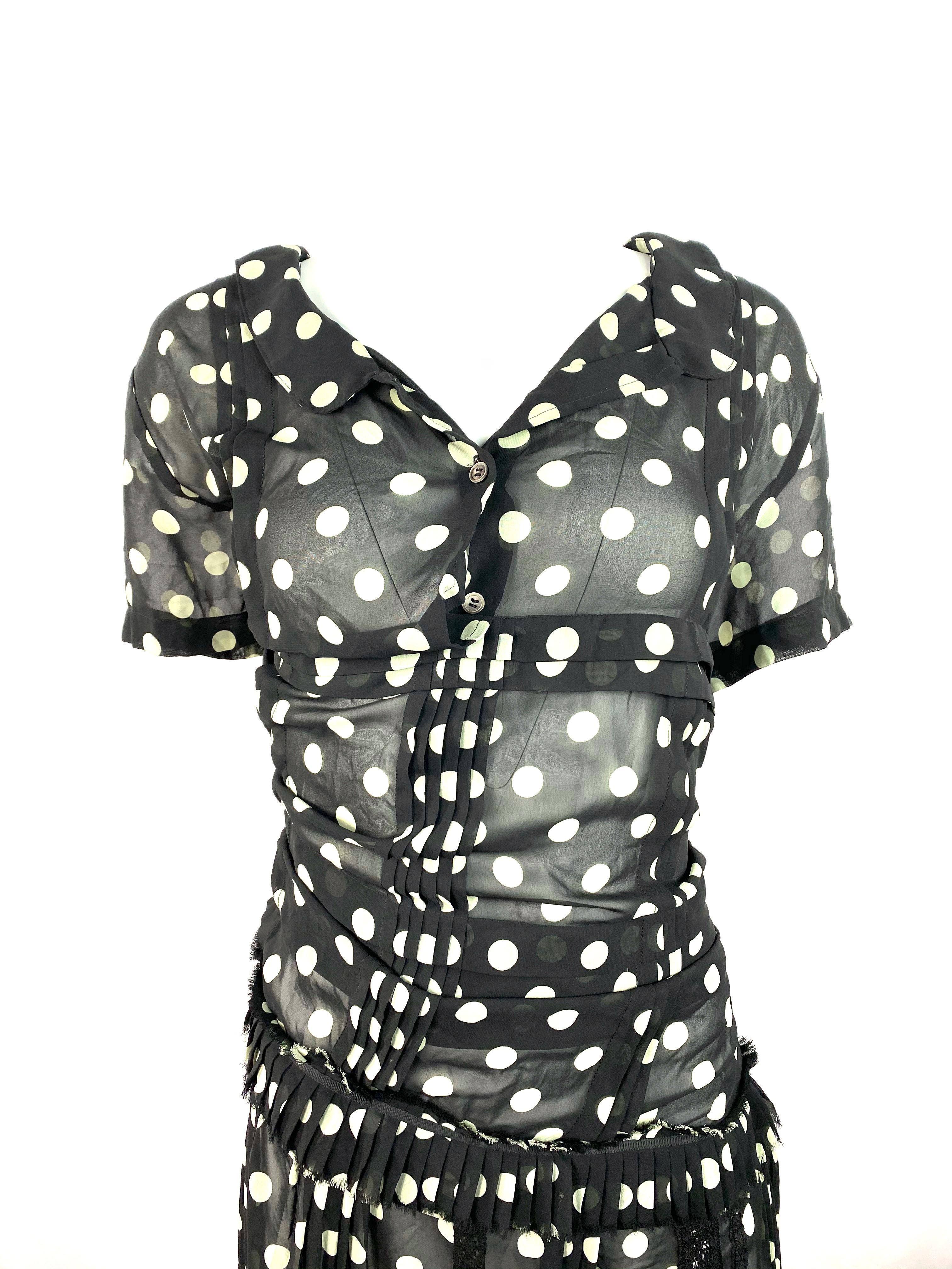 Product details:

Size small
Featuring black and white polka dot pattern, see through, asymmetrical design, ruffle and lace details, collar, front button closure and rear silver tone zipper closure.
Made in Japan.