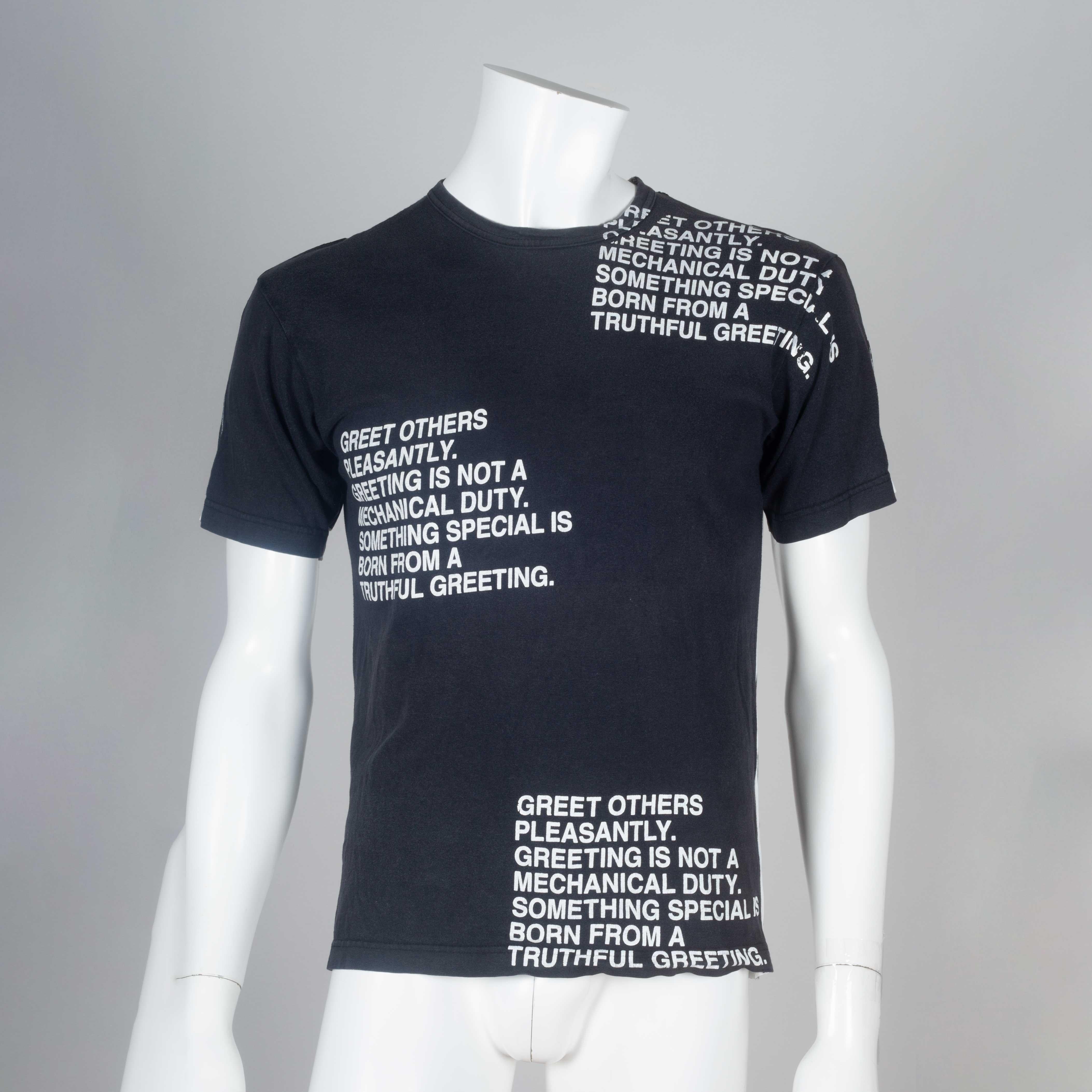 Junya Watanabe Comme des Garçons 2001 black and white distressed poem tee shirt from Japan. Poem reads:

Greet others pleasantly. Greeting is not a mechanical duty. Something special is born from a truthful greeting.

Black and white thick vertical