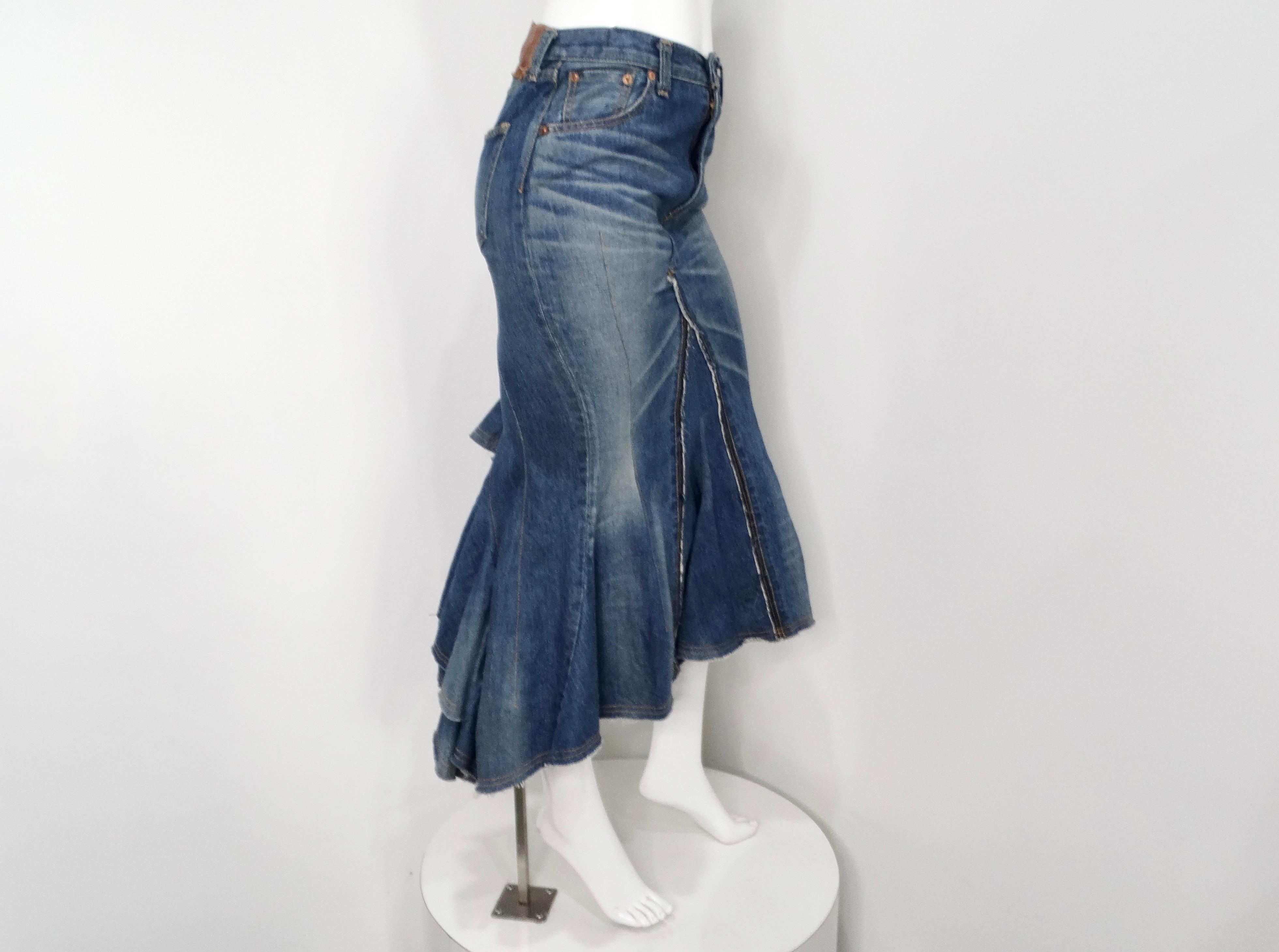 The Junya Watanabe Comme des Garçons Long Denim Ruffle Back Skirt is a striking piece that merges avant-garde design with timeless denim aesthetics. This mermaid-style skirt is characterized by its dramatic ruffle detail at the back, adding movement