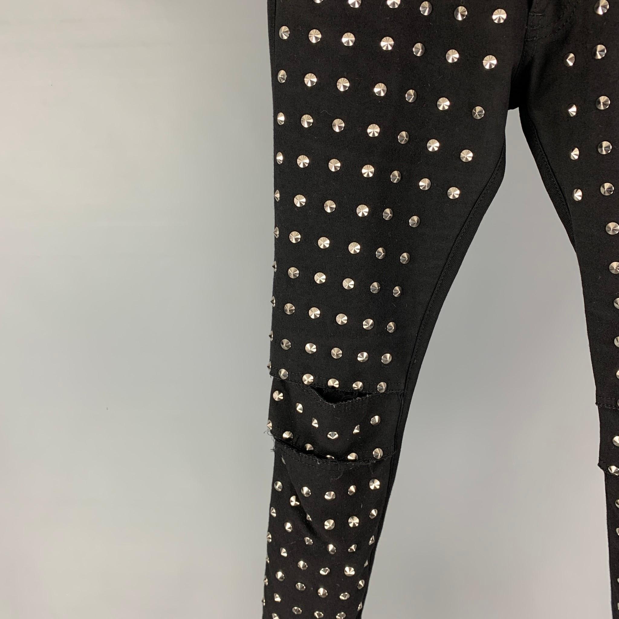 JUNYA WATANABE jeans comes in a black material featuring a low rise, skinny fit, silver tone studded details, cut-out, and a zip fly closure.

Very Good Pre-Owned Condition. Fabric tag removed.
Marked: Size tag removed.

Measurements:

Waist: 30