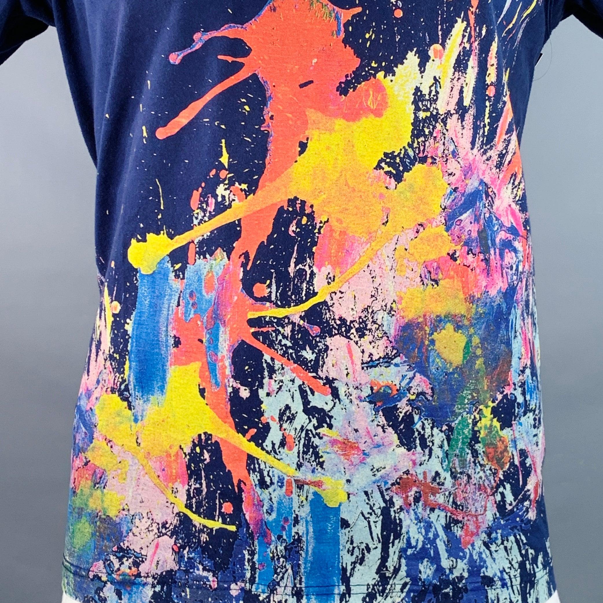 Camiseta JUNYA WATANABE
en jersey de algodón azul con diseño de salpicaduras de pintura multicolor, manga corta y cuello redondo. Made in Japan. Muy buen estado de conservación. Pequeños signos de desgaste. 

Marcado:   L 

Medidas: 
 
Hombro 18