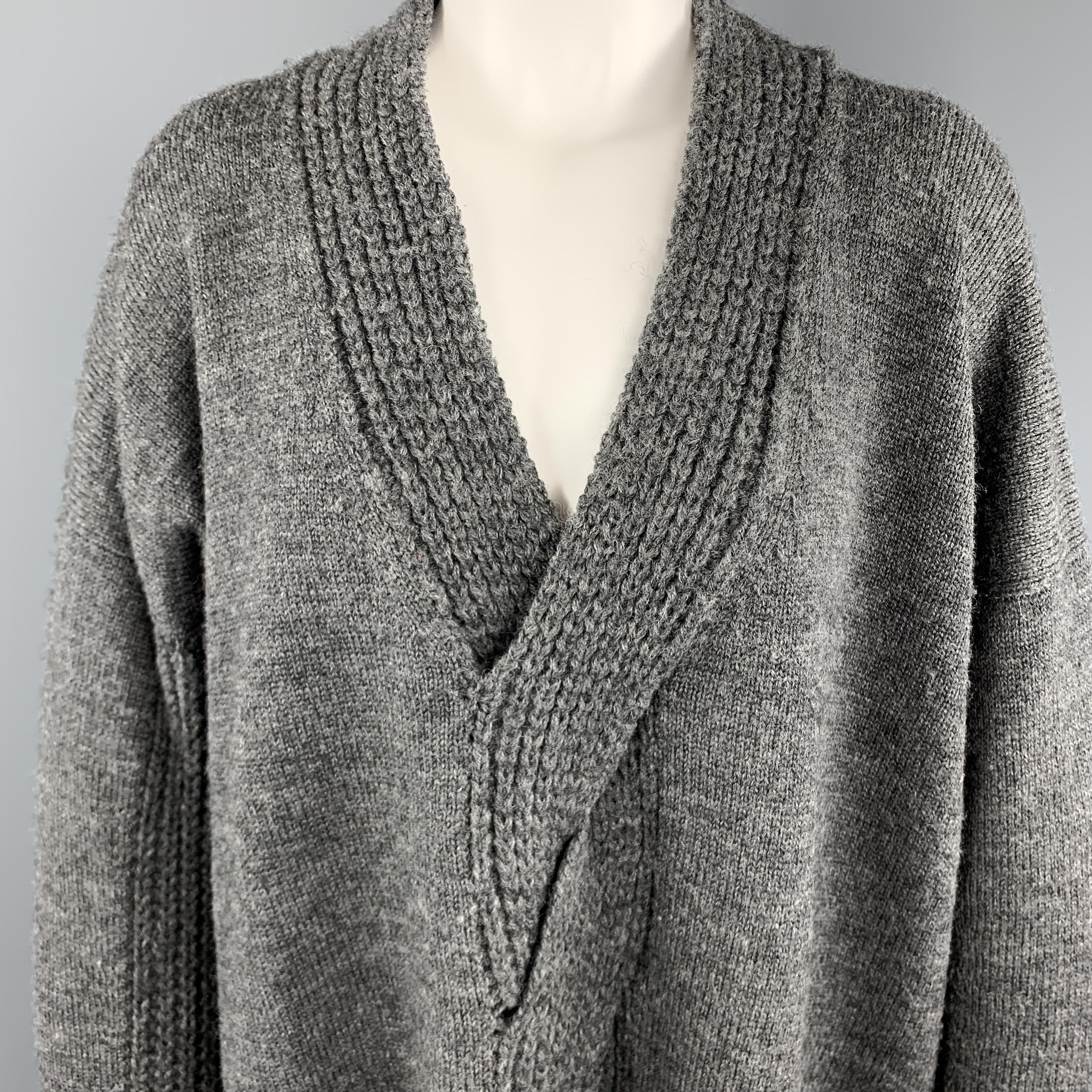 JUNYA WATANABE oversized sweater comes in dark heather gray wol knit with a deep V neck, and woven cutout cable knit center detail. Made in Japan.

Excellent Pre-Owned Condition.
Marked: M

Measurements:

Shoulder: 30 in.
Bust: 50 in.
Sleeve: 21