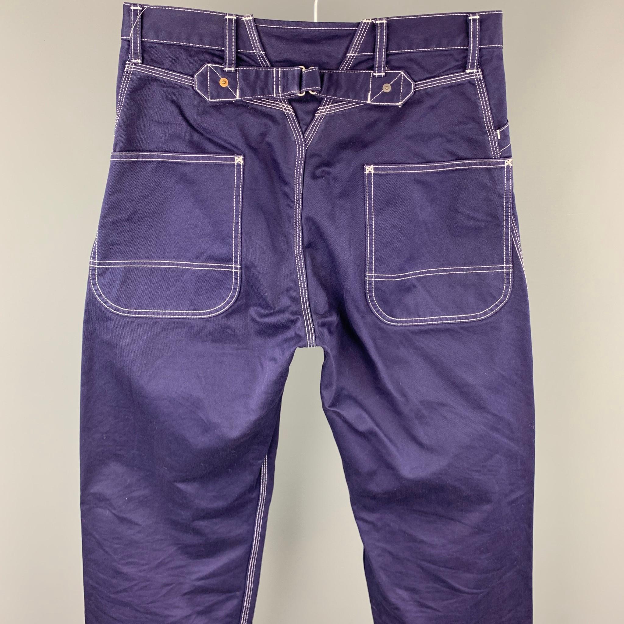 JUNYA WATANABE casual pants comes in a navy cotton with contrast stitching featuring a straight leg, back belt, and a zip fly closure. Made in Japan.

Very Good Pre-Owned Condition.
Marked: M  / AD2010

Measurements:

Waist: 32 in. 
Rise: 11 in.