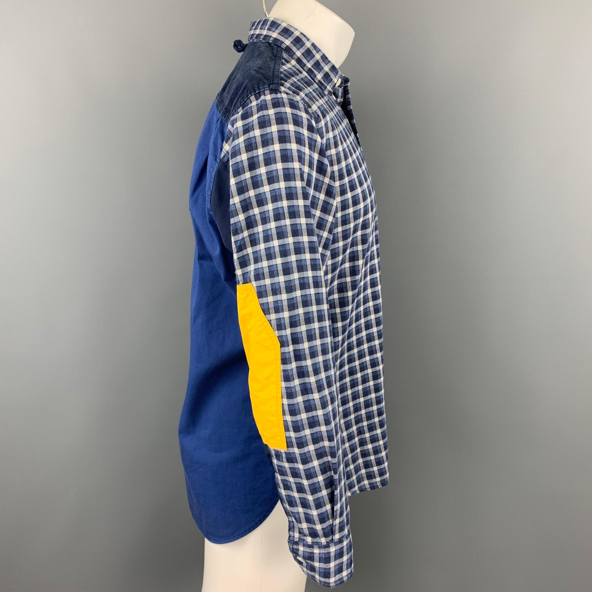 JUNYA WATANABE long sleeve shirt comes in a navy & white plaid cotton with patchwork details featuring a button up style, front pocket, elbow patches, and a spread collar. Made in Japan.

Very Good Pre-Owned Condition.
Marked: