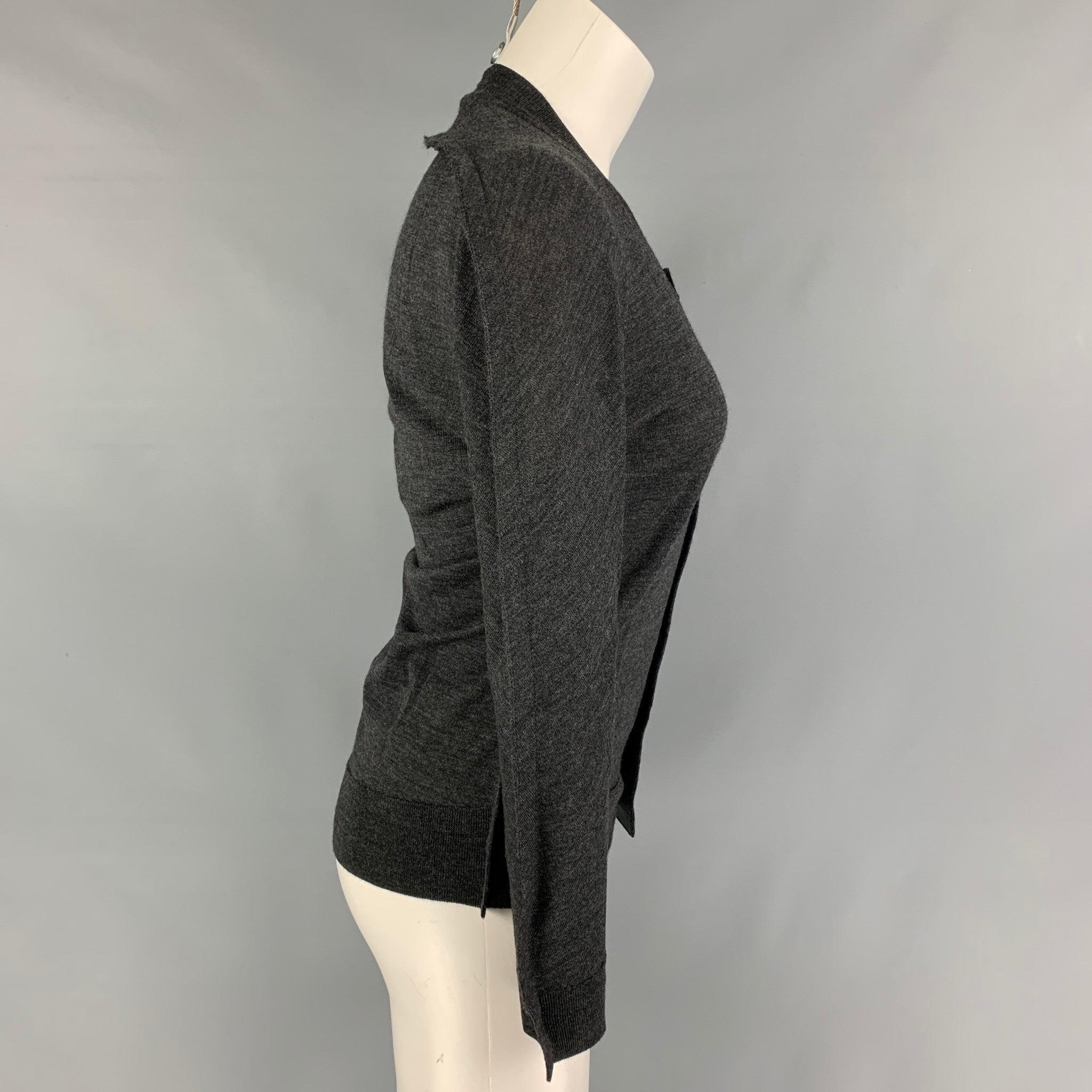 JUNYA WATANABE cardigan comes in a grey heather wool featuring structured sleeves and a buttoned closure. Made in Japan.
Excellent
Pre-Owned Condition. 

Marked:   S 

Measurements: 
 
Shoulder: 15.5 inches Bust: 34 inches Sleeve: 21 inches Length: