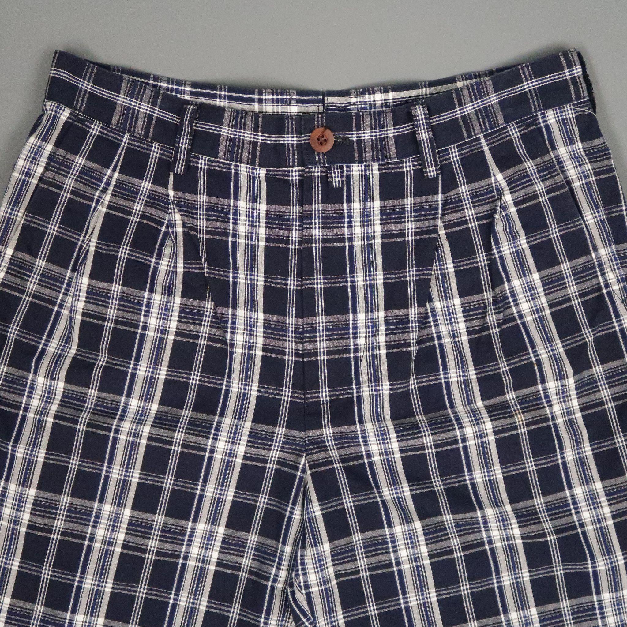 JUNYA WATANABE Shorts comes in navy and white tones in a plaid cotton material, with a pleated front, zip fly, seam and patch pockets. Made in Japan.
 
Excellent Pre-Owned Condition.
Marked: S
 
Measurements:
 
Waist: 32 in.
Rise: 12 in.
Inseam: 
