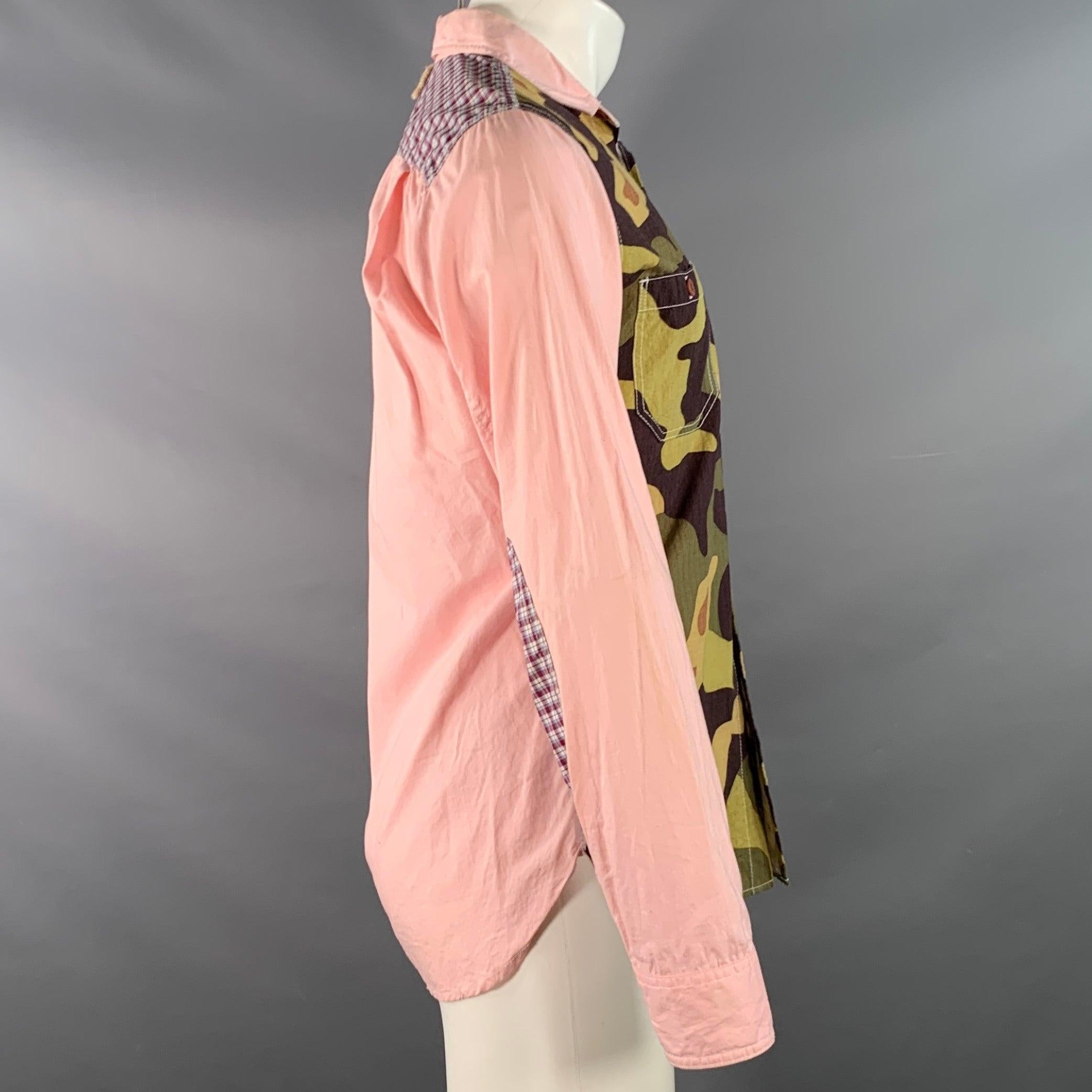 Chemise à manches longues JUNYA WATANABE
en tissu rose et multicolore (au toucher coton), avec un devant à motif camouflage, deux poches boutonnées, des épaules à motif écossais et une fermeture à boutons. Note : ce vêtement a été