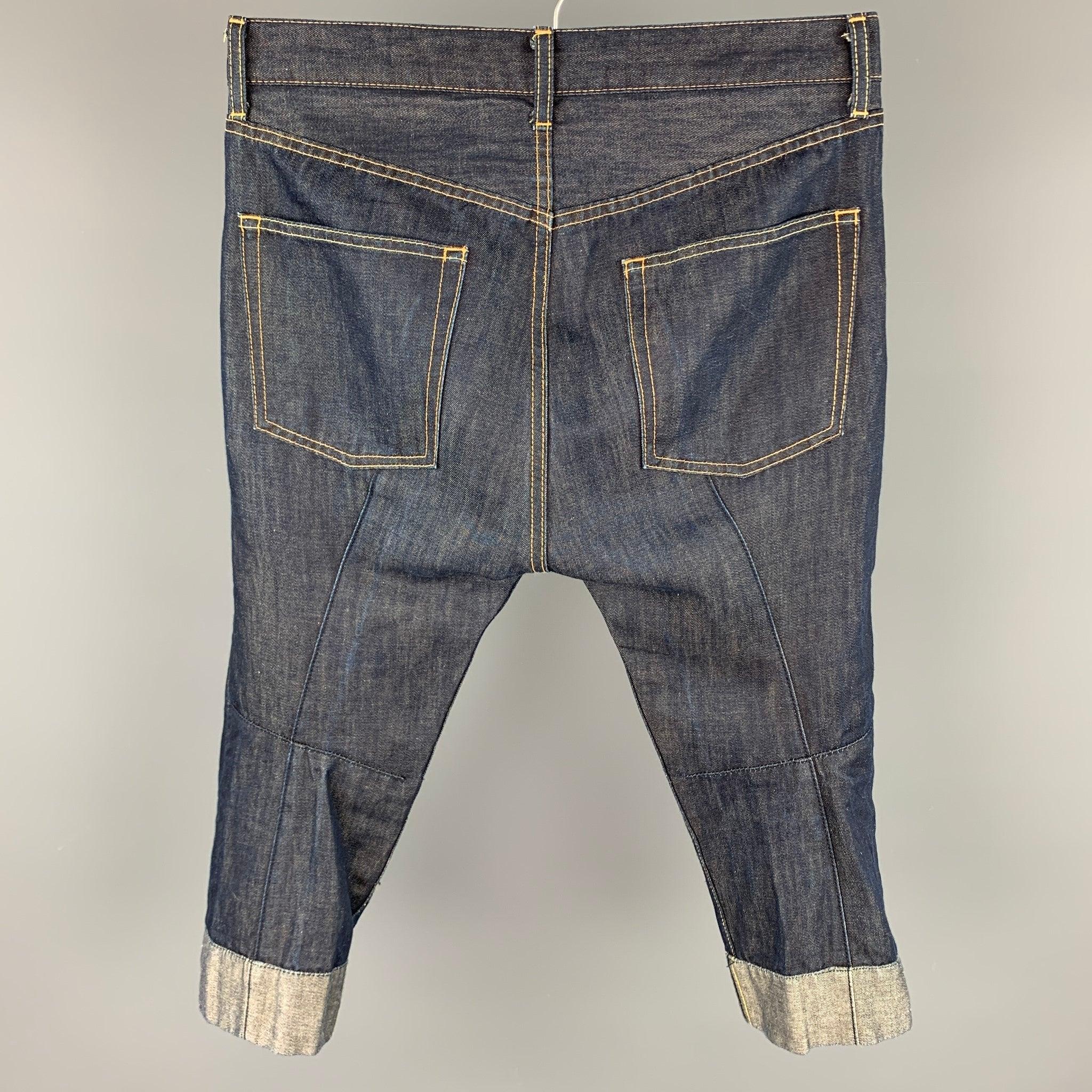 JUNYA WATANABE jeans comes in a indigo denim with contrast stitching featuring a cropped leg, folded, top stitching, and a zip fly closure. Made in Japan.
Very Good
Pre-Owned Condition. 

Marked:   SS / AD2008 

Measurements: 
  Waist: 32 inches 