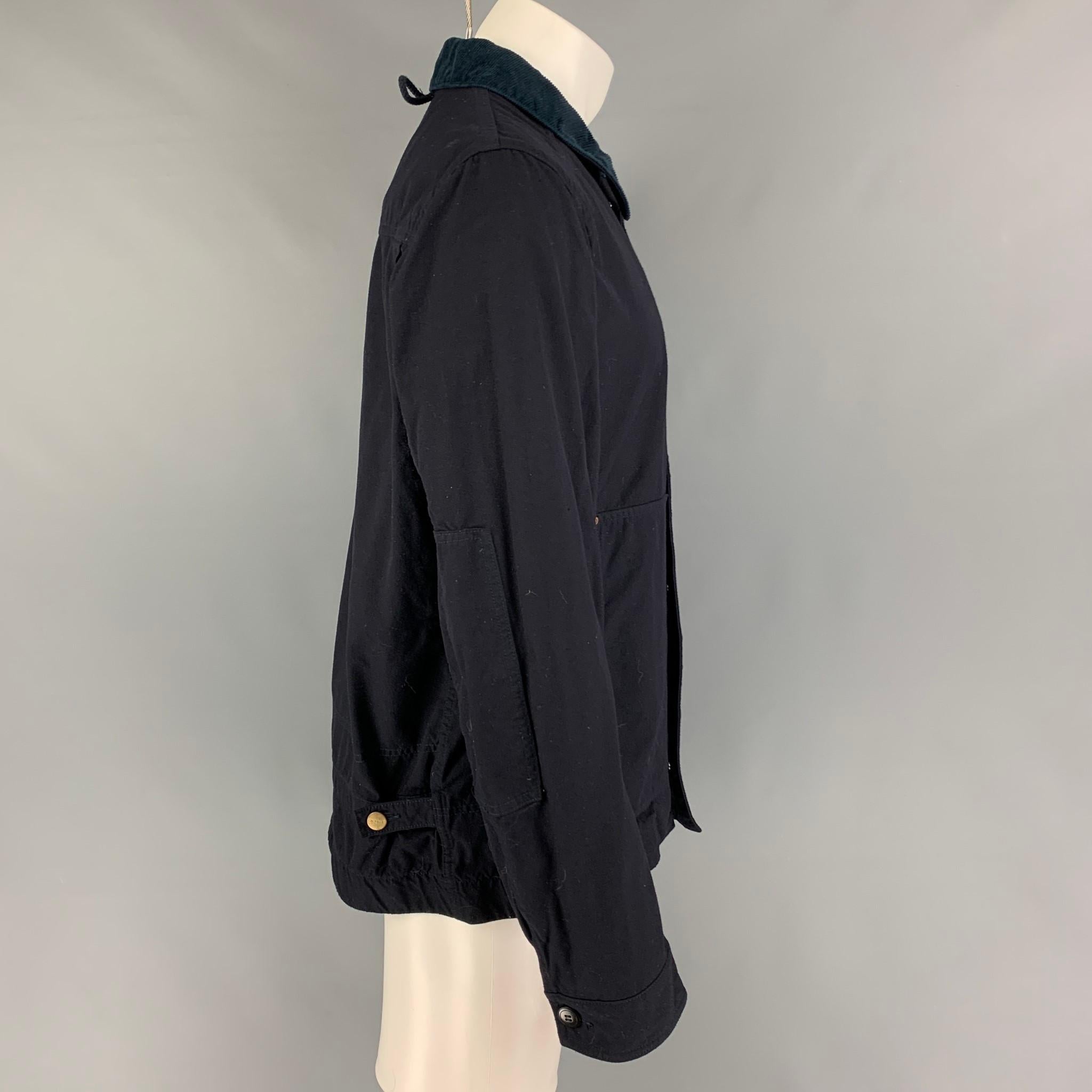 JUNYA WATANABE x CARHARTT jacket comes in a navy cotton featuring a worker style, corduroy collar, patch pockets, side tabs, and a zip & snap button closure. Made in Japan. 

Very Good Pre-Owned Condition.
Marked: L

Measurements:

Shoulder: 18