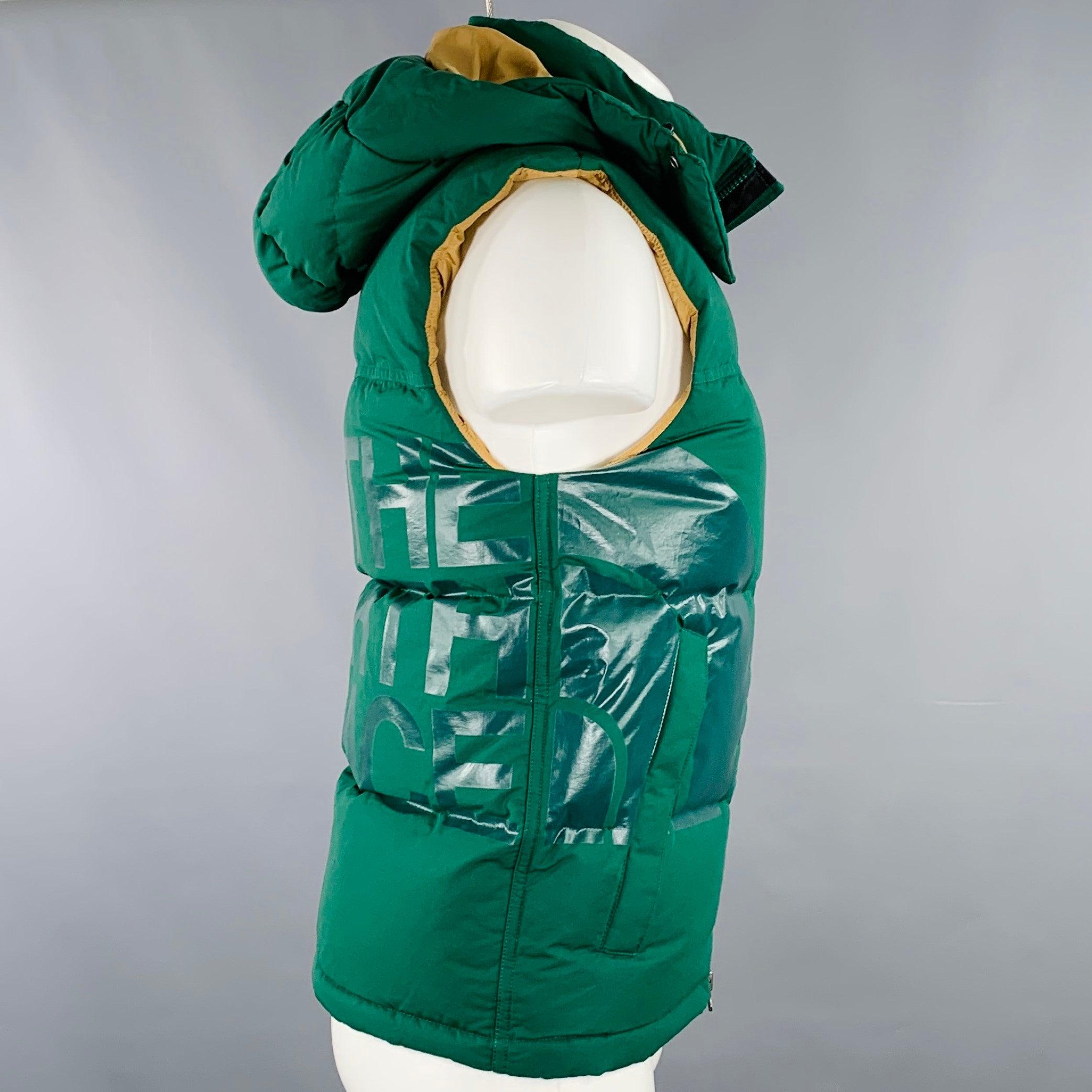 JUNYA WATANABE x THE NORTH FACE vest
in a green cotton nylon woven blend fabric featuring a quilted and down-filled style, snap hood, THE NORTH FACE logo print on back, and zip up closure. New with Tags. 

Marked:   XS 

Measurements: 
 
Shoulder: