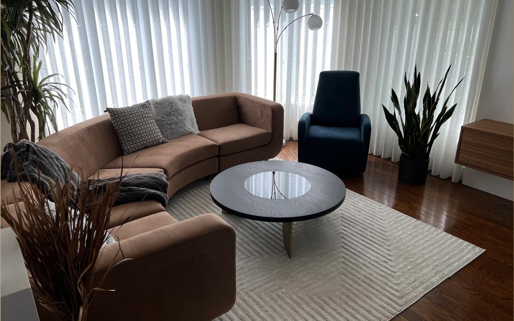 La table basse Jupiter est fabriquée à la main à partir d'une épaisse surface en bois massif et comporte une surface circulaire en verre teinté qui éclaircit la surface et permet une certaine réflexion de la lumière. La surface en bois massif est