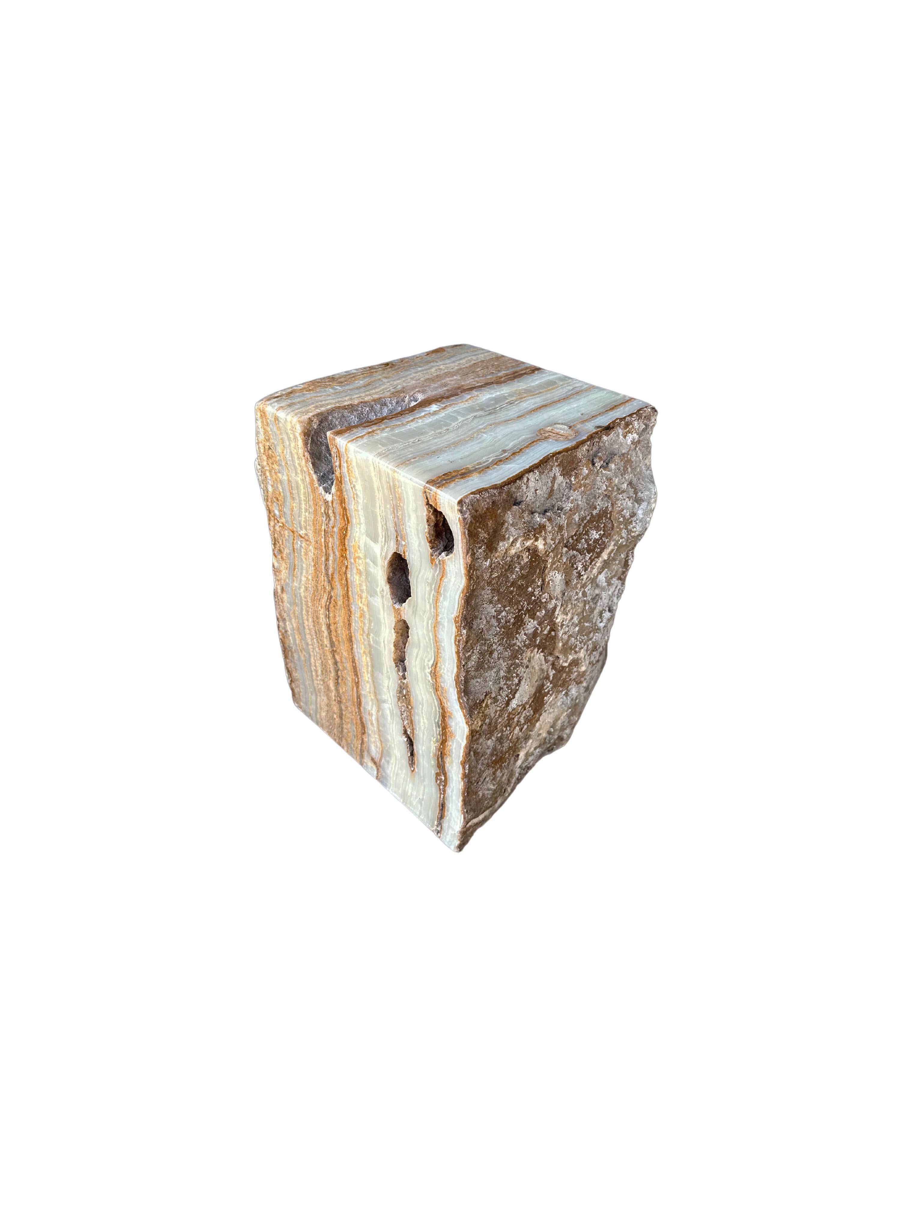Un bloc de marbre massif Jupiter onyx qui sert de table d'appoint ou de piédestal. Provenant de l'île de Sumatra et présentant des nuances de terre et de vert jade, cet objet brut et organique présente un mélange étonnant de textures et de nuances.