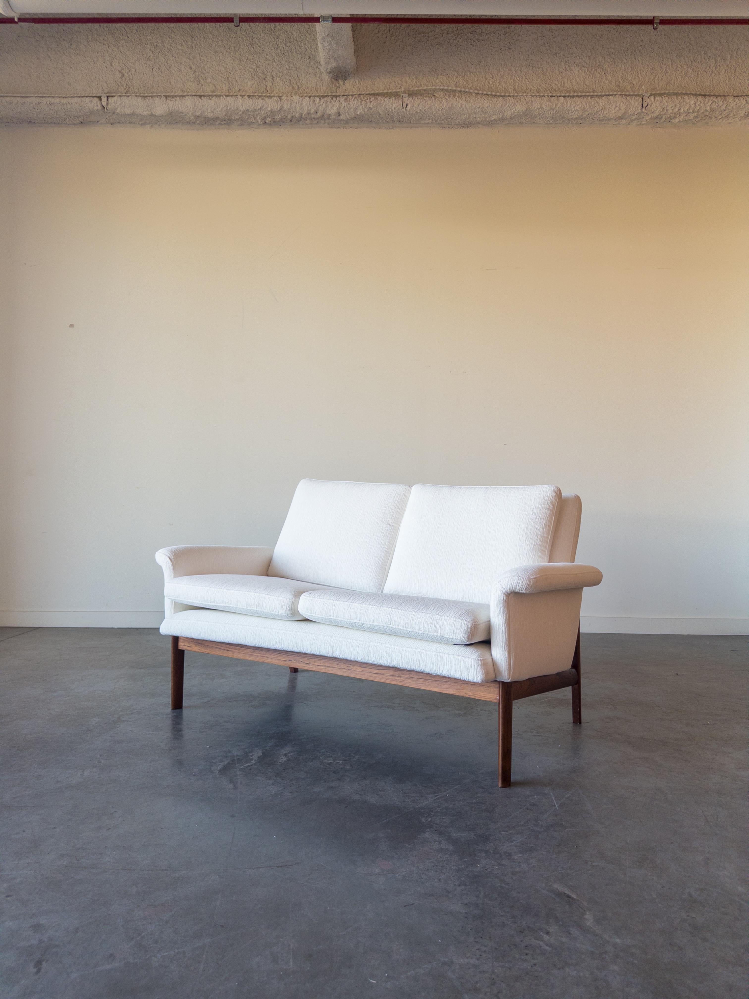Jupiter sofa model 218 designed by Finn Juhl and manufactured by France and Son, Denmark 1965. The sofa has a solid teak frame and white Holly Hunt Fabric seating. Sofa is marked with the France and Son tag underneath the seat.

