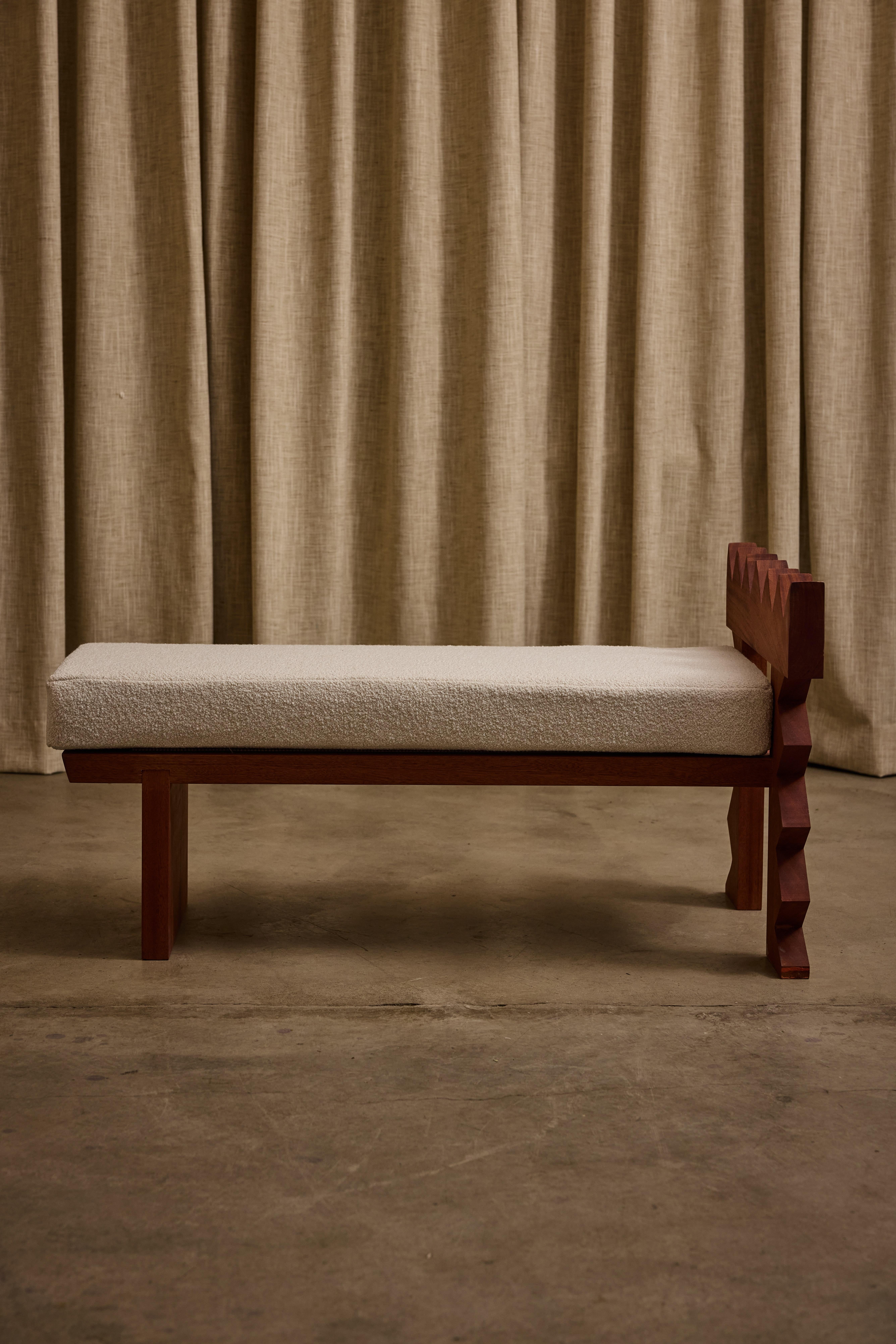 Jura Bench by Ah Um Design Studio
Handmade
Dimensions: D 106.6 x W 63.5 x H 55.9 cm.
Materials: Mahogany wood, oil finish, white bouclé.

Available in other upholstery and finish options. Please contact us.

Hand-carved wood, an angular design, and