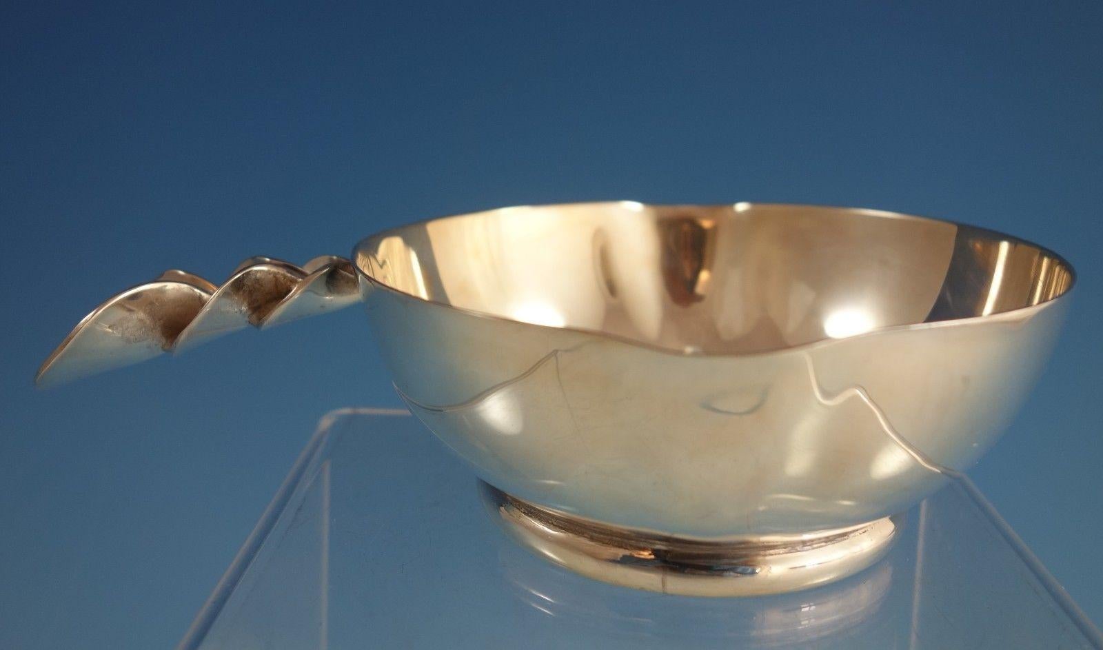 Modernist Mexican sterling silver sauce bowl that was made by Jurentino Lopez Reyes. The bowl has two spouts, it measures 1 3/4 tall x 6 1/2 long, and it weighs 7 ozt. It is not monogrammed and is in excellent condition. Captivating! 

     
    