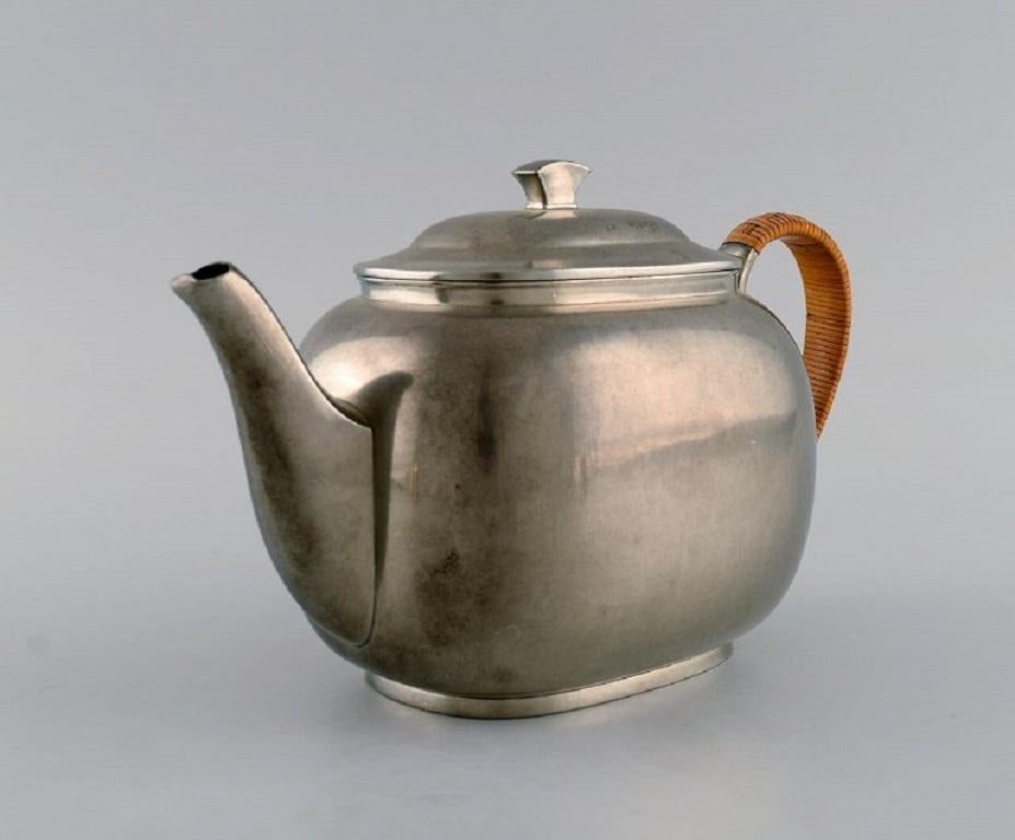 Just Andersen (1884-1943), Denmark. 
Art Deco tin teapot with wicker handle. 1940s. 
Model number 2421.
Measures: 22 x 15 cm.
In excellent condition with patina.
Stamped.