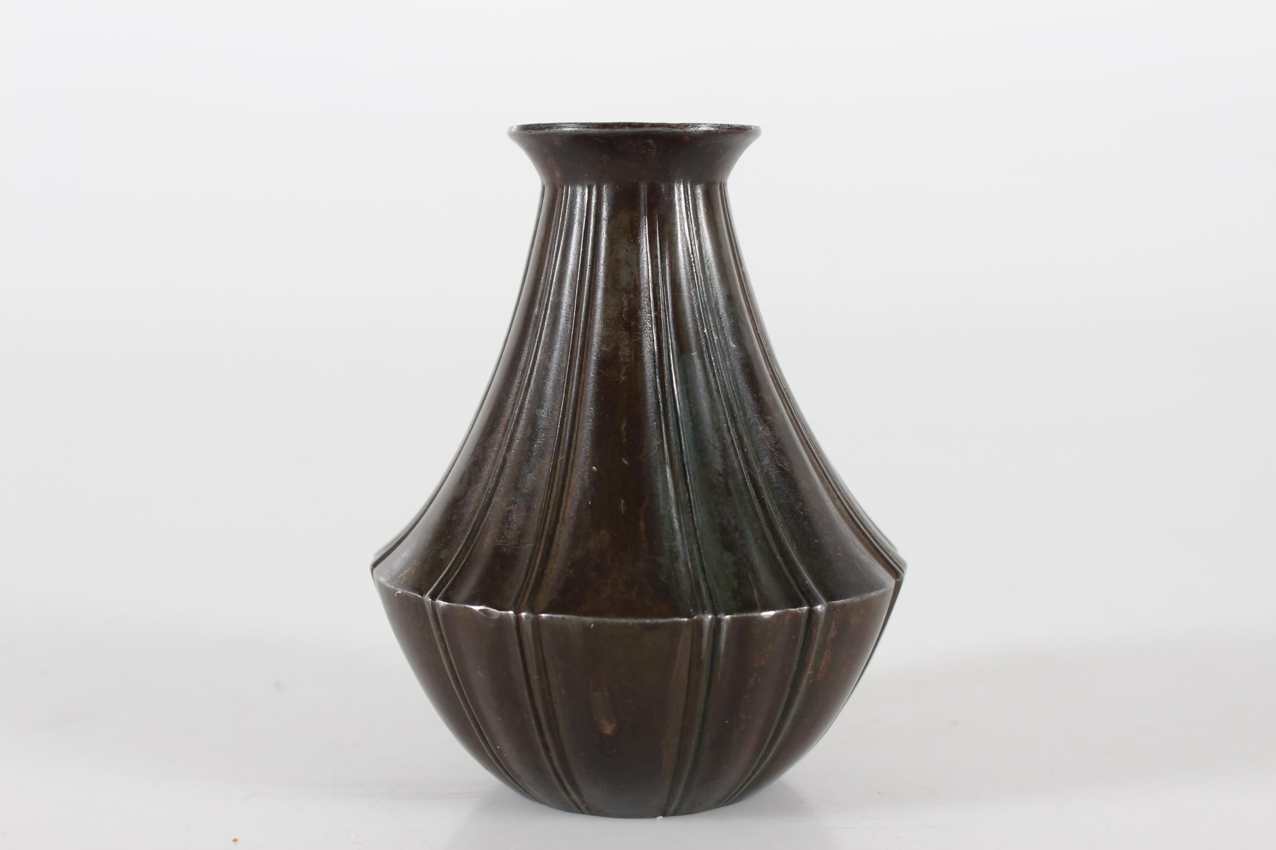 Decorative Art Deco vase made of disco metal with brown patina.
It's designed and made by the Danish artist Just Andersen (1884-1943) in the 1930s.

Sign. with monogram for Just Andersen + Denmark + D 2192

Nice condition with good patina, small