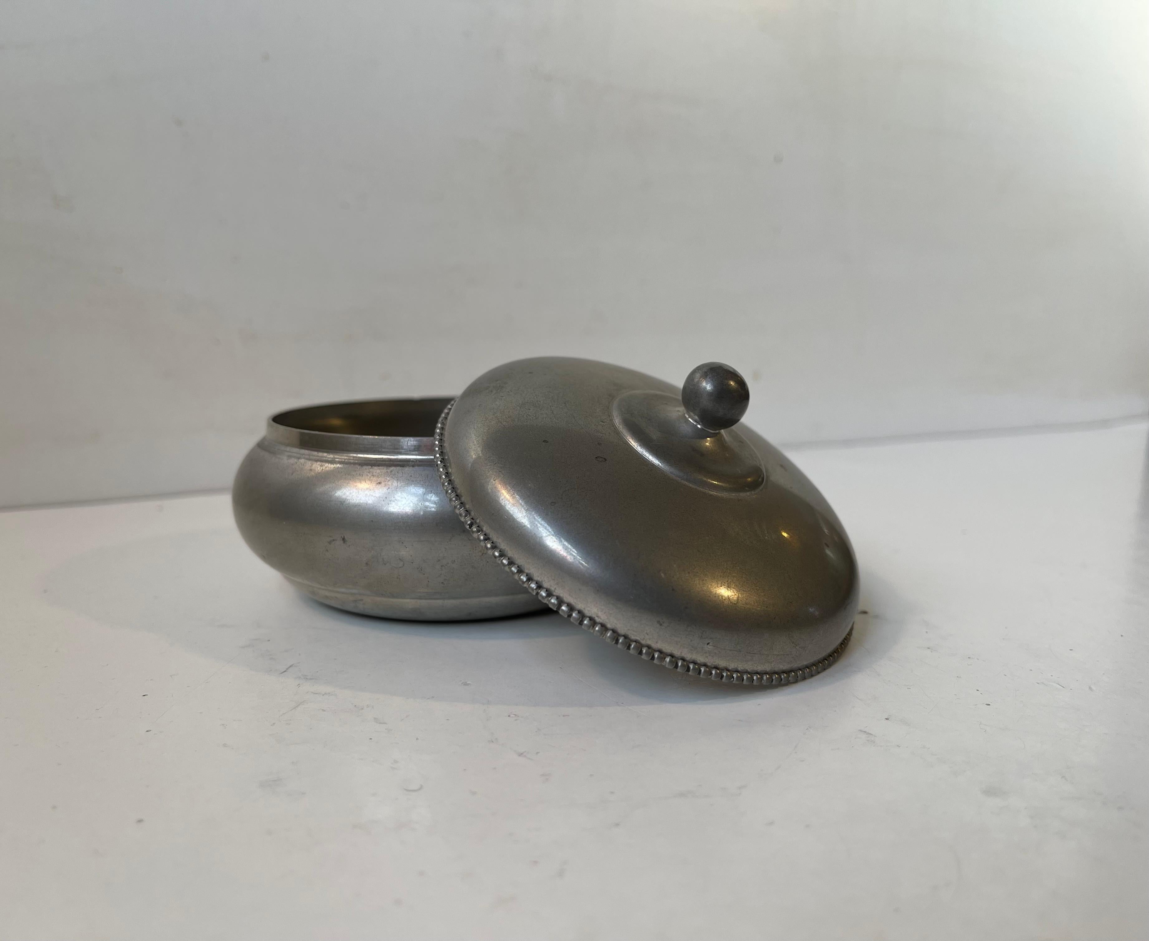 A rare pewter trinket in pewter. Clean strict design with beaded edge. Designed and manufactured by Just Andersen in Denmark during the 1930s. Imprinted to its base: Just, Danmark, 2783. Measurements: H: 7 cm, W/D: 10 cm.

Free World wide express