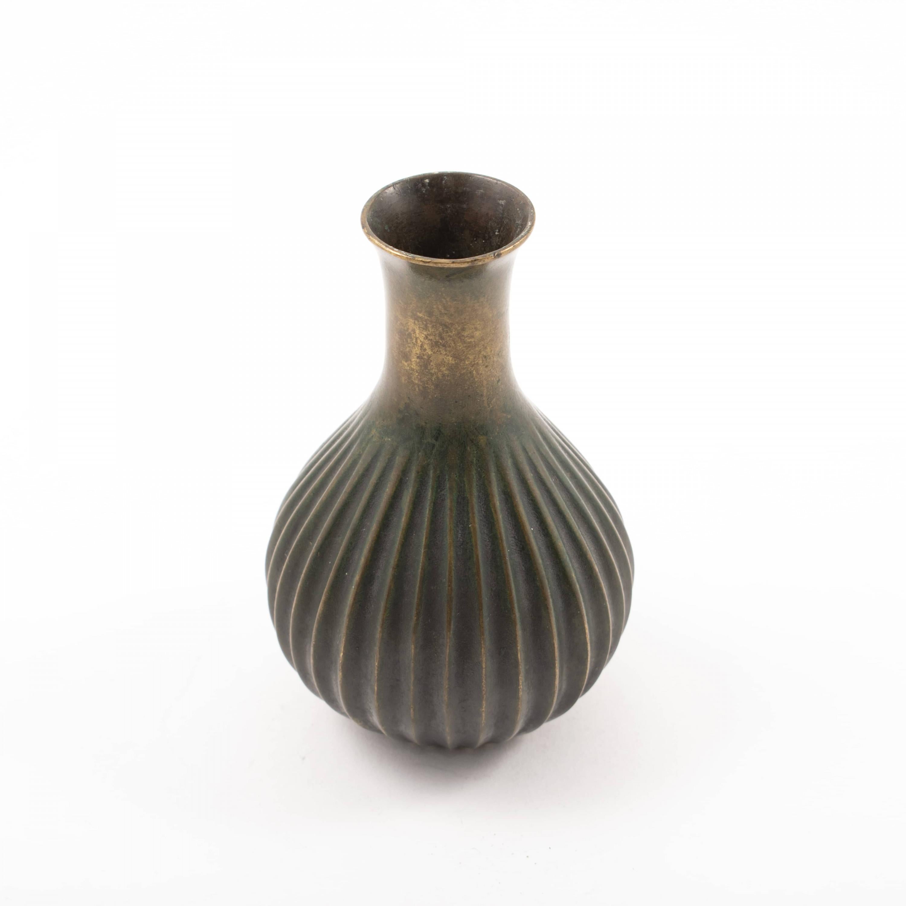 Just Andersen (1884-1943)
Small Art Deco vase in green patinated bronze. Ribbed body and smooth neck. Model number B127.
Stamped JUST,
Denmark, c. 1925-1930.
Measure: H. 12.5 cm.
