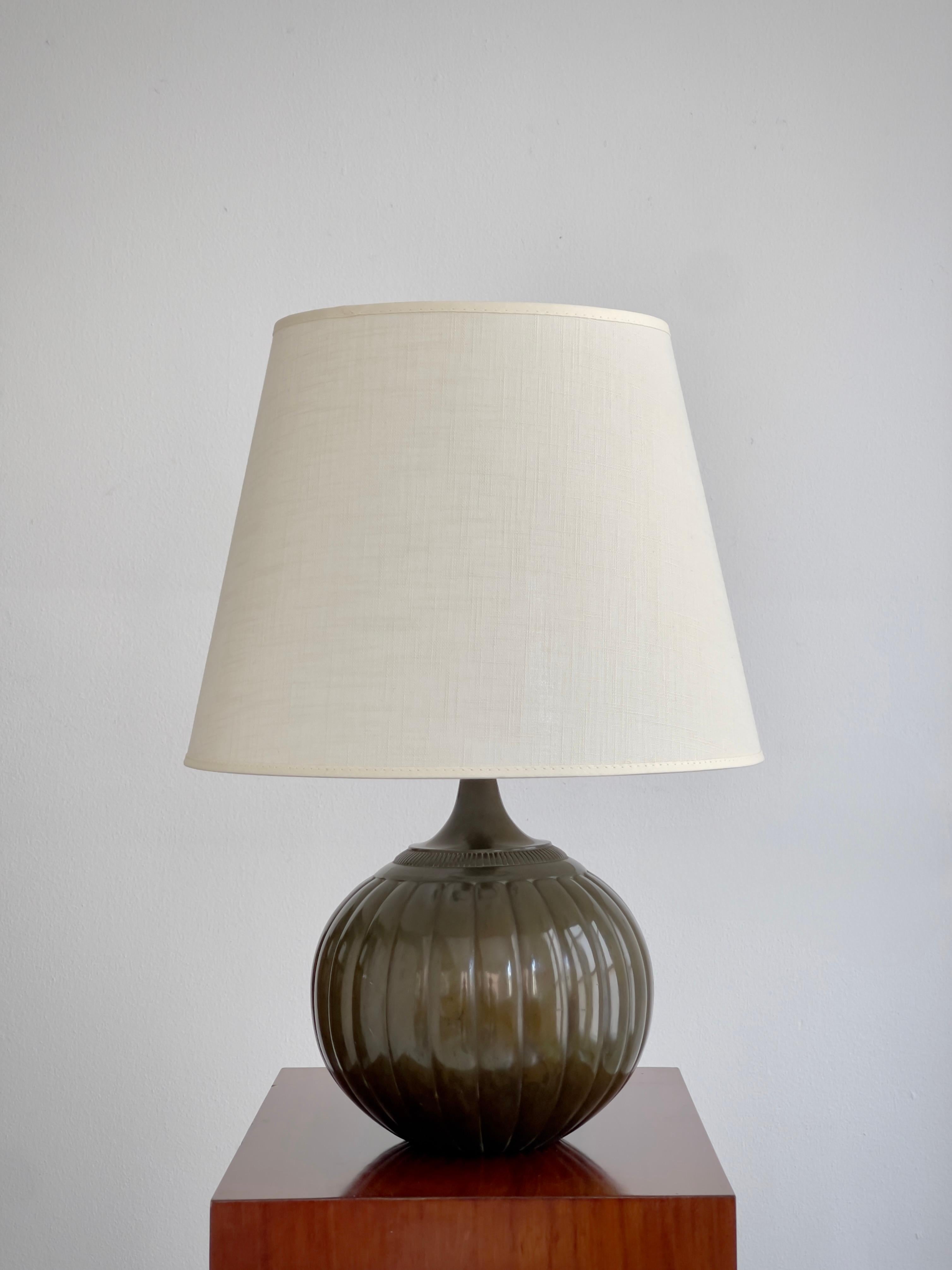 Conçue en 1934 par le célèbre sculpteur danois Just Andersen, cette rare lampe de table ronde - modèle 1632 - est un exemple raffiné des arts décoratifs scandinaves du début du XXe siècle, où les objets fonctionnels ont été élevés au rang d'élégance