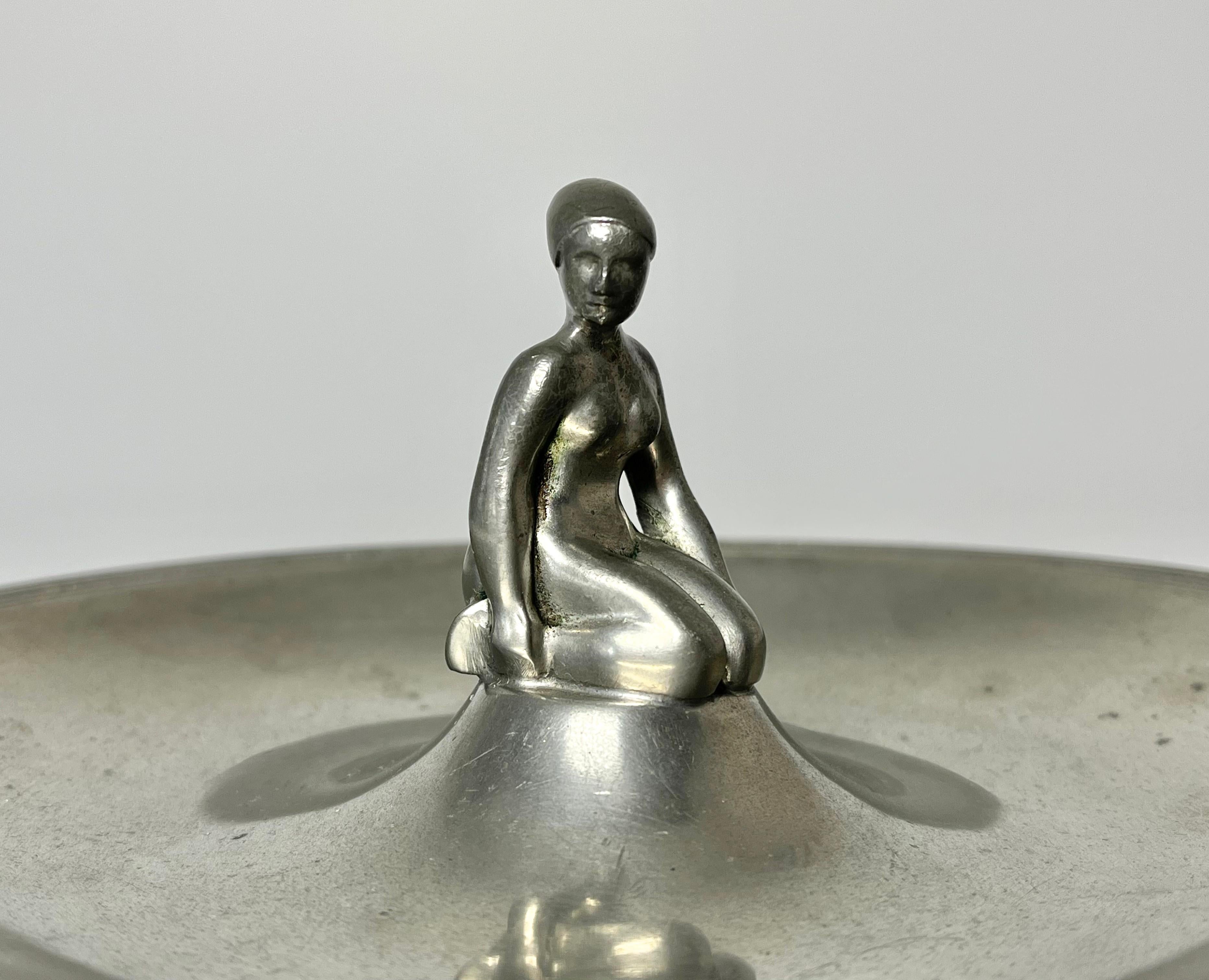 Just Andersen, aus Dänemark 1930er Jahre Zinn Art Deco vide poche
Die zentrale Figur einer knienden, badenden Frau weist hervorragende Details und Patina auf.
Ungefähr 1930er Jahre
Auf dem Sockel gestempelt und nummeriert 829C
Durchmesser 7