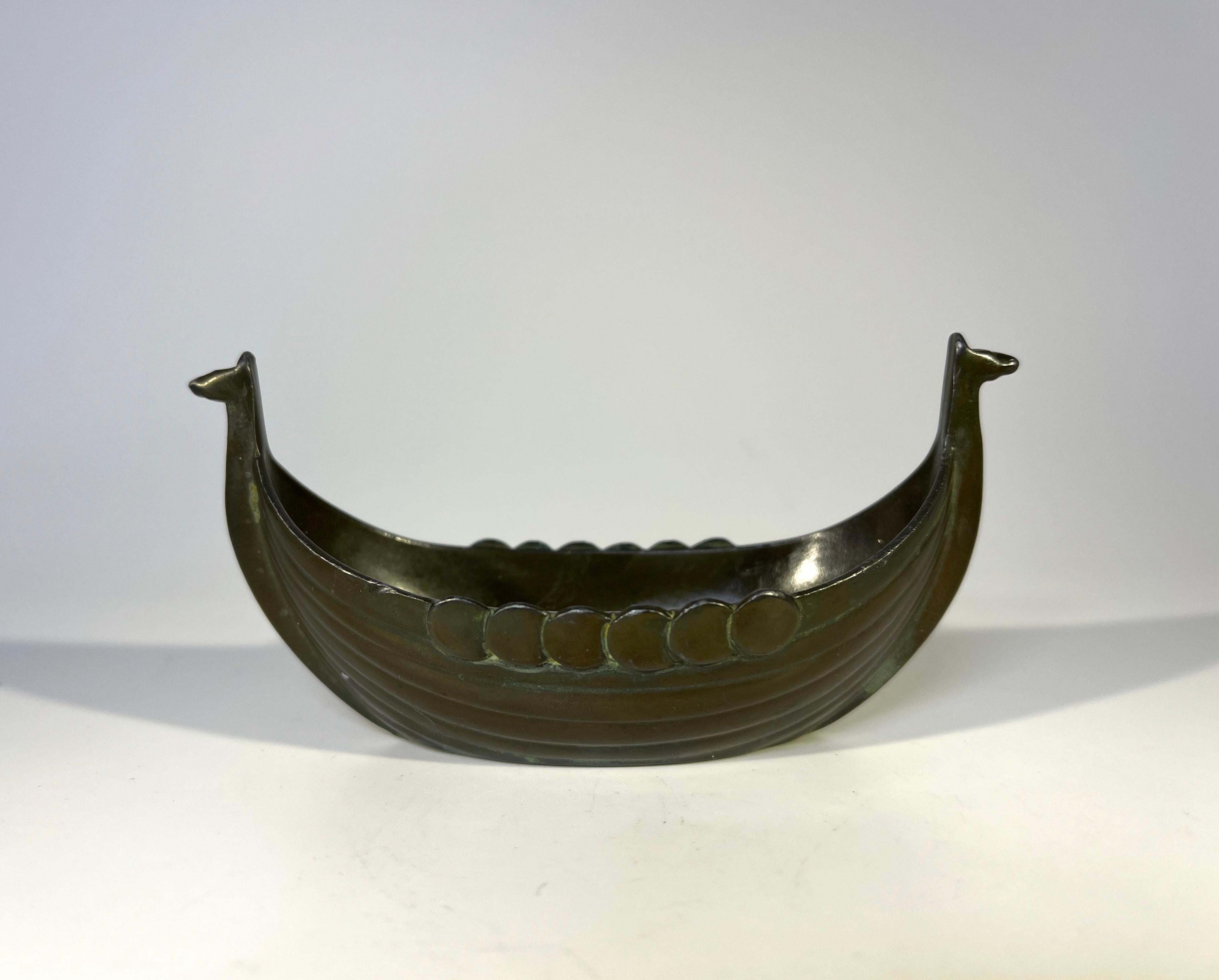 Just Andersen Danish bronze patina Disko metal Viking ship salt cellar. 
Circa 1920's
Estampillé et numéroté 1109 sur la base
Hauteur 2,25 pouces, Largeur 4,25 pouces, Profondeur 1,75 pouce
En bon état. 