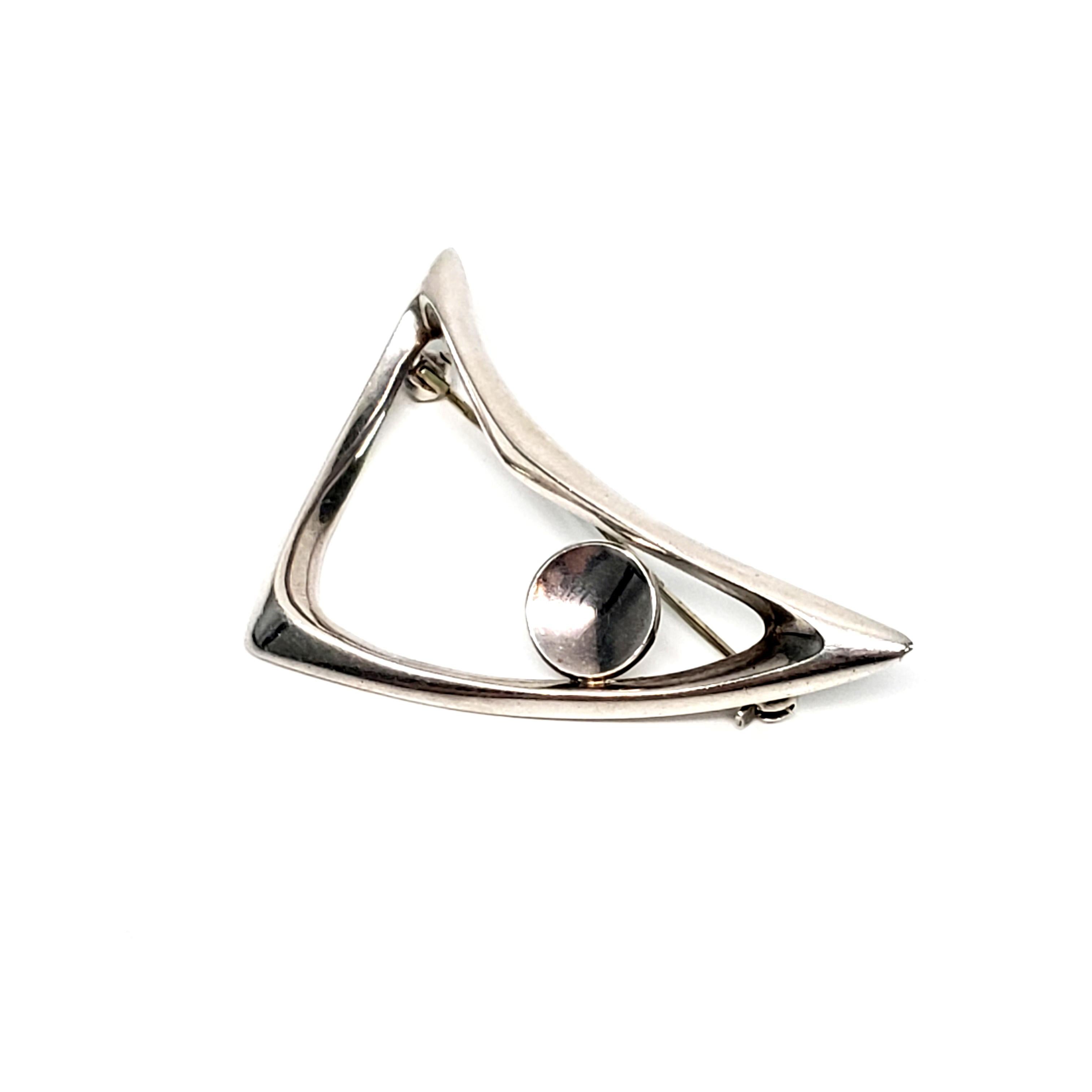 Sterling silver boomerang style pin #777 by Just Andersen of Copenhagen, Denmark.

This beautiful asymmetrical modernist piece was designed by Just Andersen, a Danish designer of the early 20th century. The exceptional craftsmanship of his classic