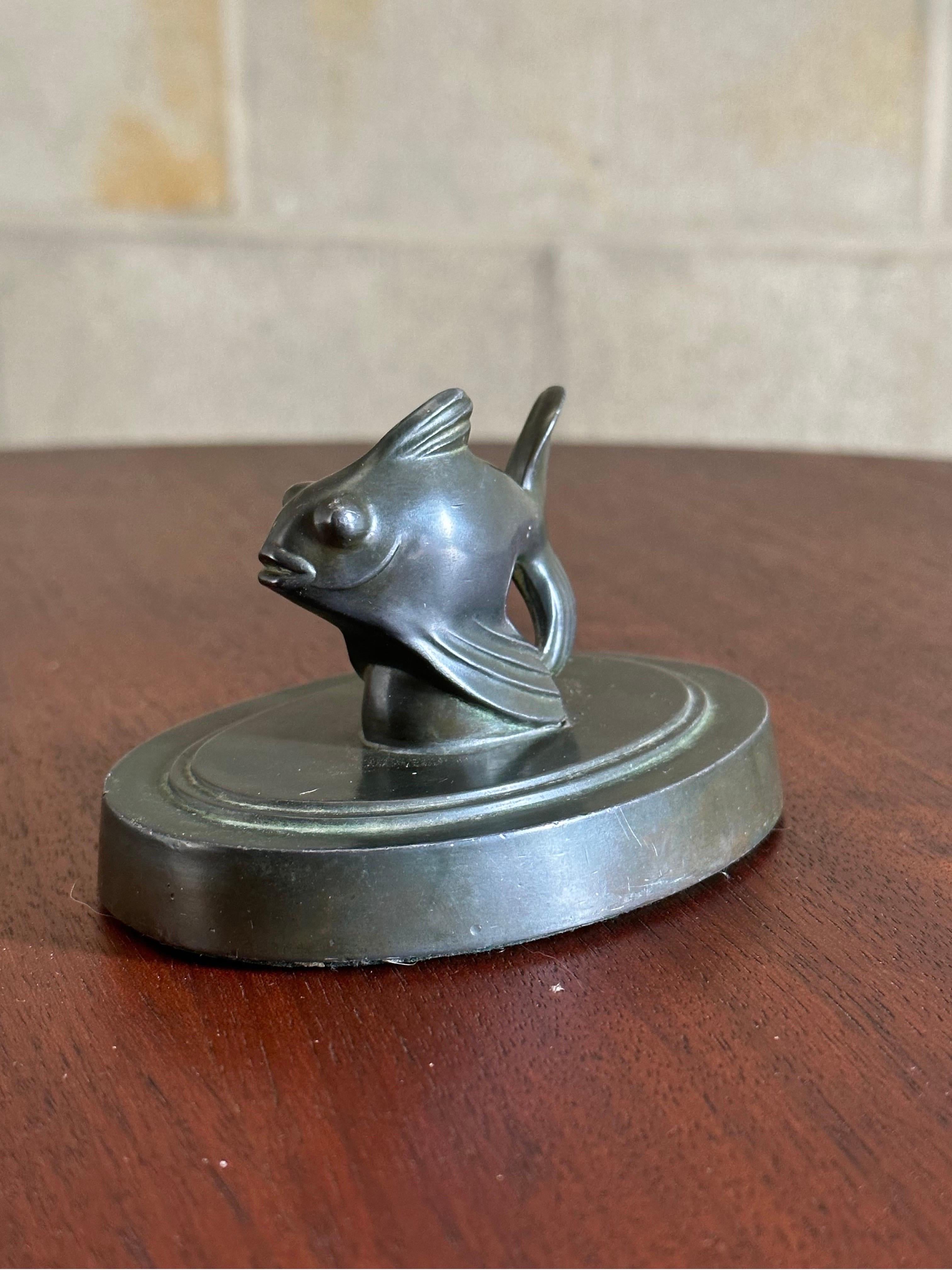 A Heavy metal (likely pewter) paperweight designed by Just Andersen. Paperweight depicts a Fantail Fish. A lovely Art Deco style piece which can work in a variety of different interiors including modern, mid century, contemporary, and traditional.