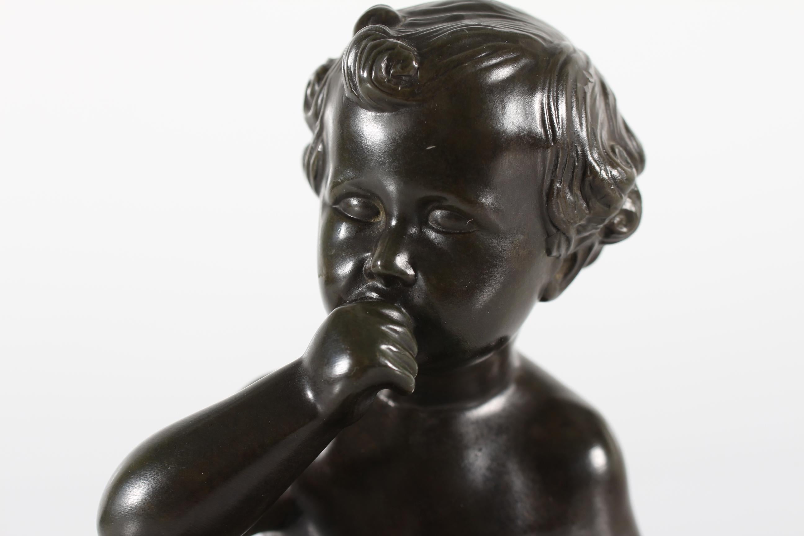 Statuetta originale disegnata dall'artista e scultore danese Just Andersen (1884-1943) con un ragazzo nudo seduto su un piatto di marmo.
Questa particolare statuetta è stata lanciata per la prima volta nel 1942. È realizzato in Danimarca con il