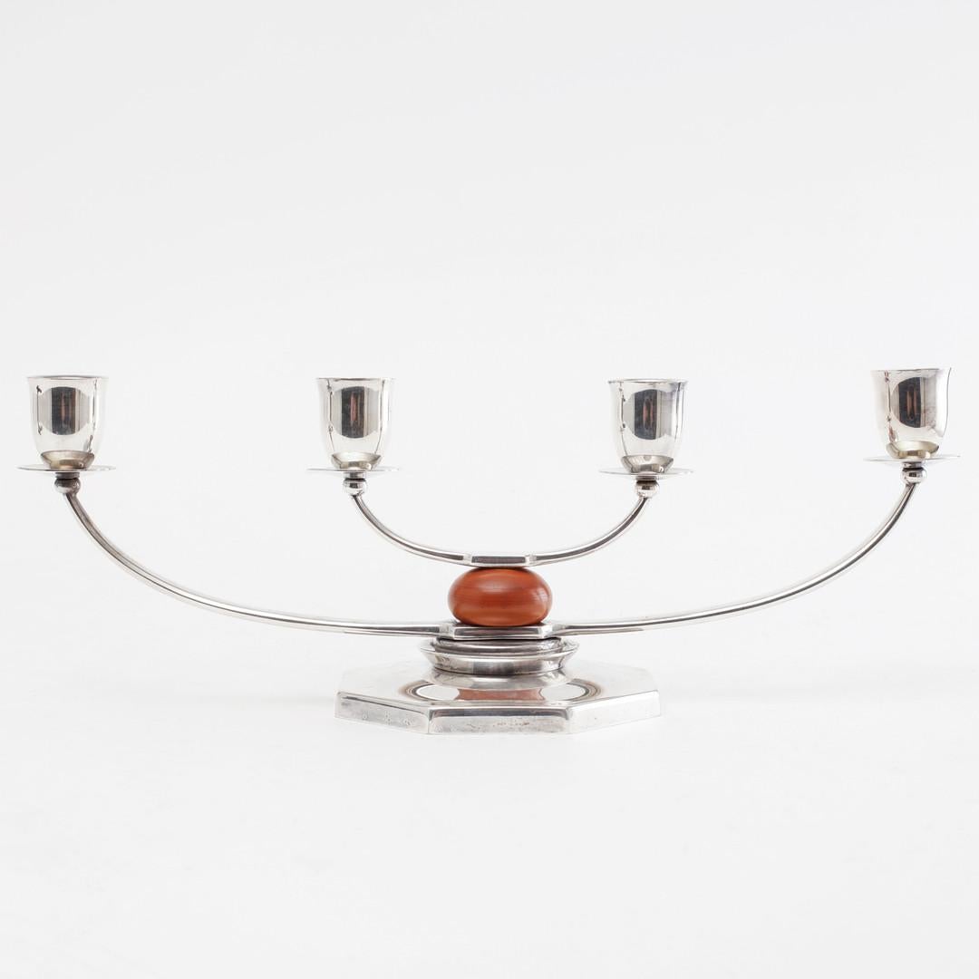 Un par de candelabros de cinco brazos bañados en plata, bellamente equilibrados, diseñados por el escultor y diseñador danés Just Andersen para GAB (Guldsmedsaktiebolaget), Suecia, hacia 1930. Estas llamativas piezas presentan la mezcla