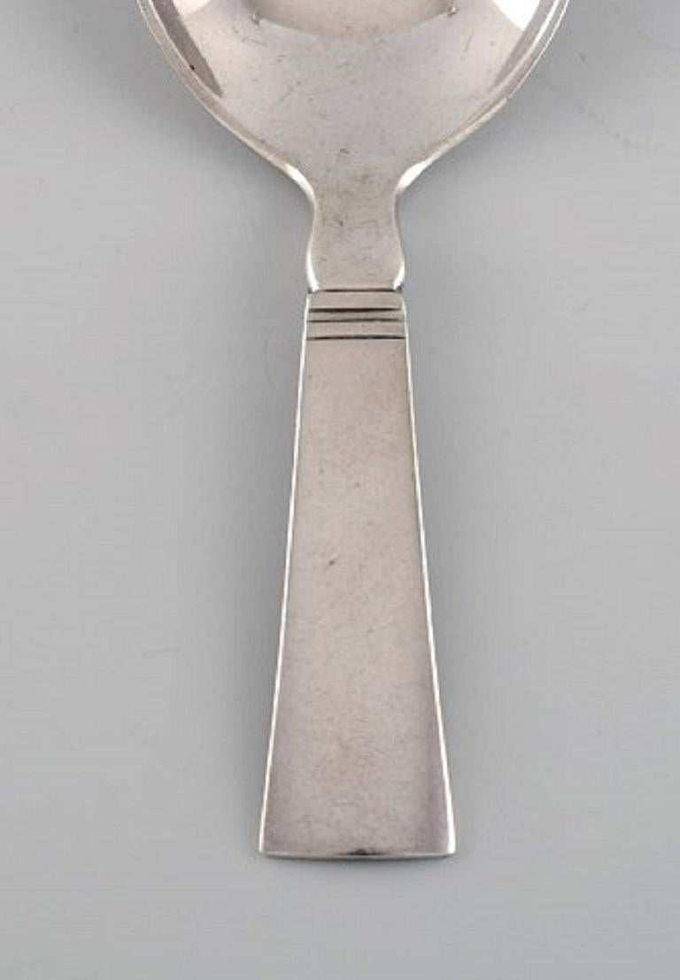 Just Andersen for Georg Jensen. Blok / Acadia jam spoon in sterling silver.
Dated 1933-1944.
Measure: Length: 10 cm.
In excellent condition.
Stamped.
Designed by Just Andersen, 1934.
Our skilled Georg Jensen silversmith / goldsmith can polish