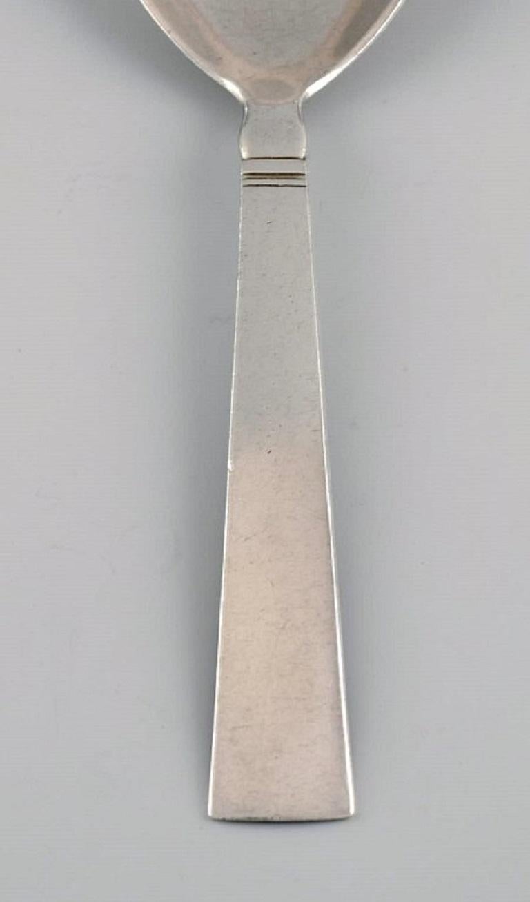 Just Andersen for Georg Jensen. Blok / Acadia serving spoon in sterling silver. 
Dated 1933-1944.
Length: 20 cm.
In excellent condition.
Stamped.
Designed by Just Andersen, 1934.
Our skilled Georg Jensen silversmith / goldsmith can polish all