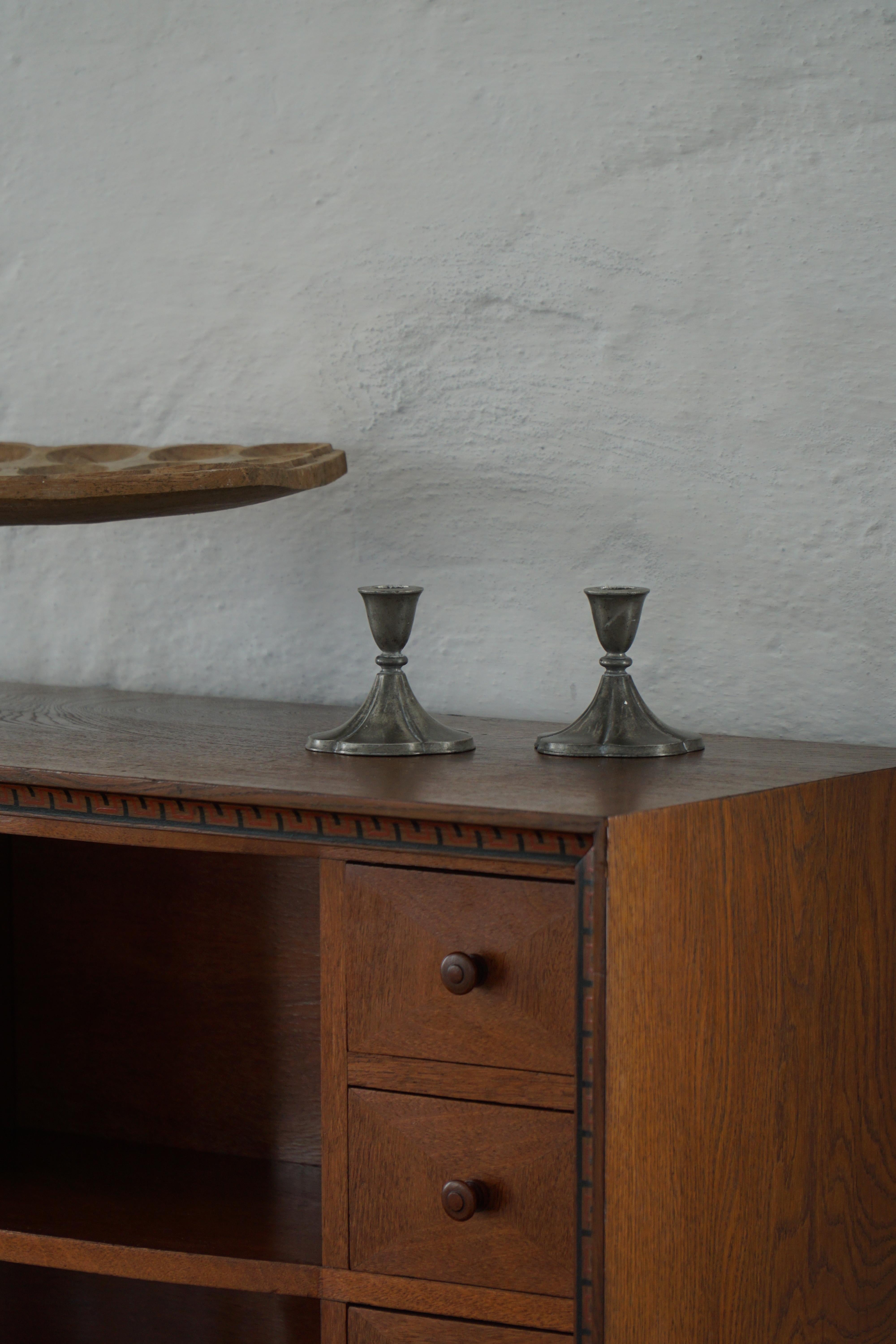 Charmante paire de bougeoirs en étain conçus par Just Andersen dans les années 1930, destinés à accueillir des bougies. Ces élégantes pièces du début de la Modern Scandinavian Modern sont imprégnées de subtiles influences Art Deco, mettant en valeur