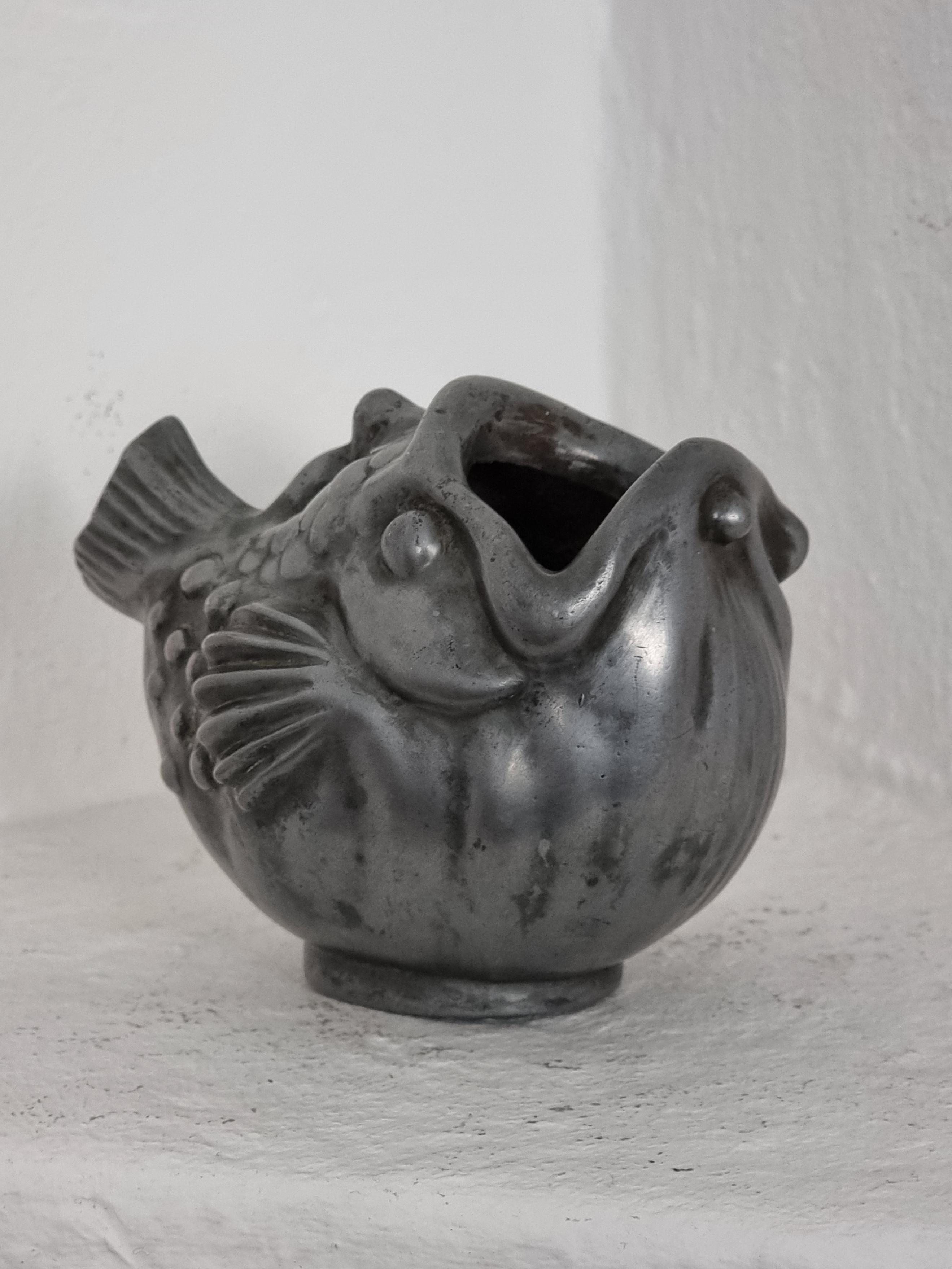 Seltene, dekorative Vase aus Zinn mit einer Fischdarstellung. Hergestellt von Just Andersen, Dänemark 1930er Jahre. 

In gutem Zustand, Boden mit kleineren Kratzern.  Normale Anzeichen von Alter und Abnutzung.
