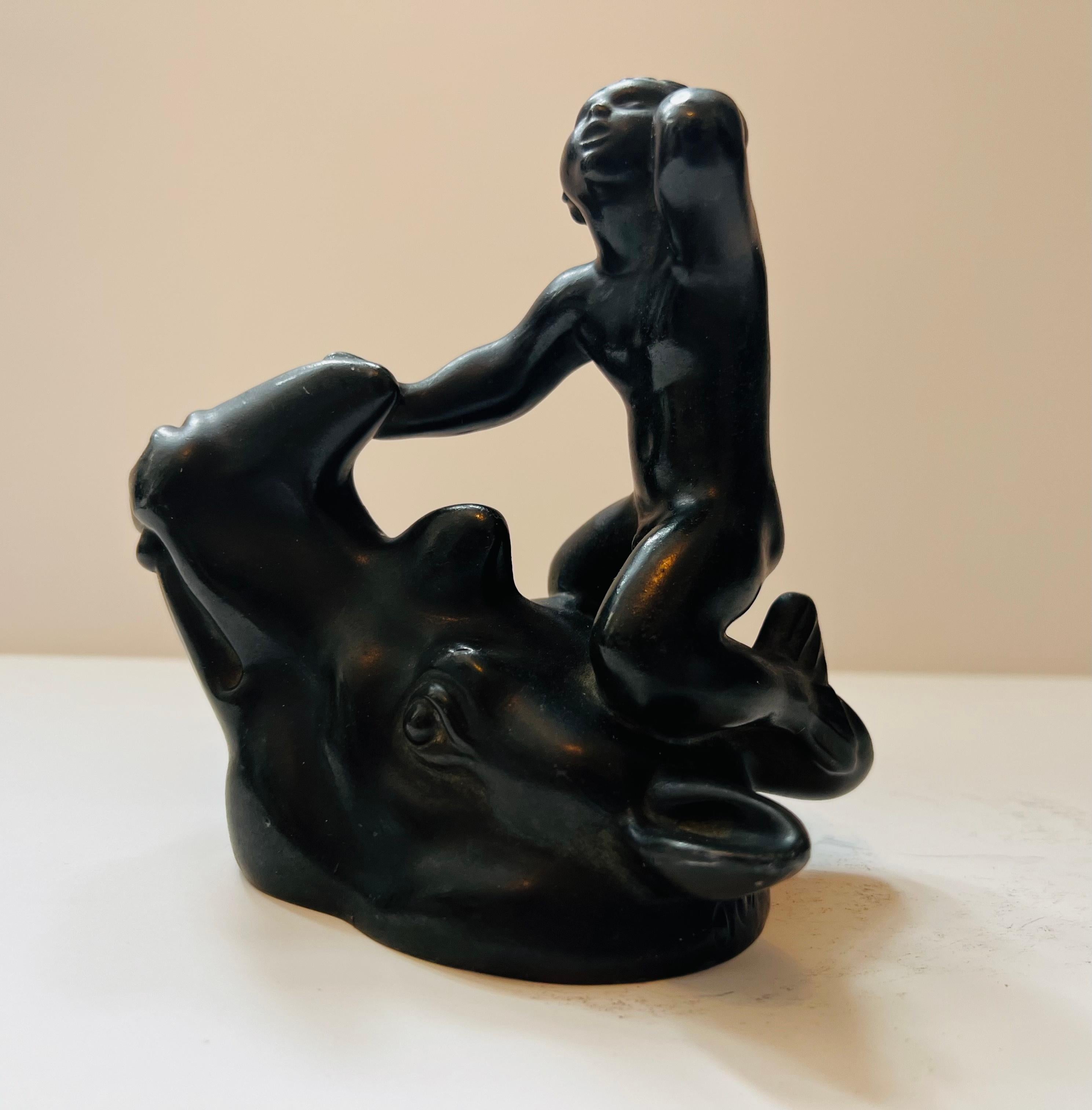 A rare Jus Andersen sculpture or paperweight in patinated bronze called “Disko” of a Merman atop of a rhino head. Signed