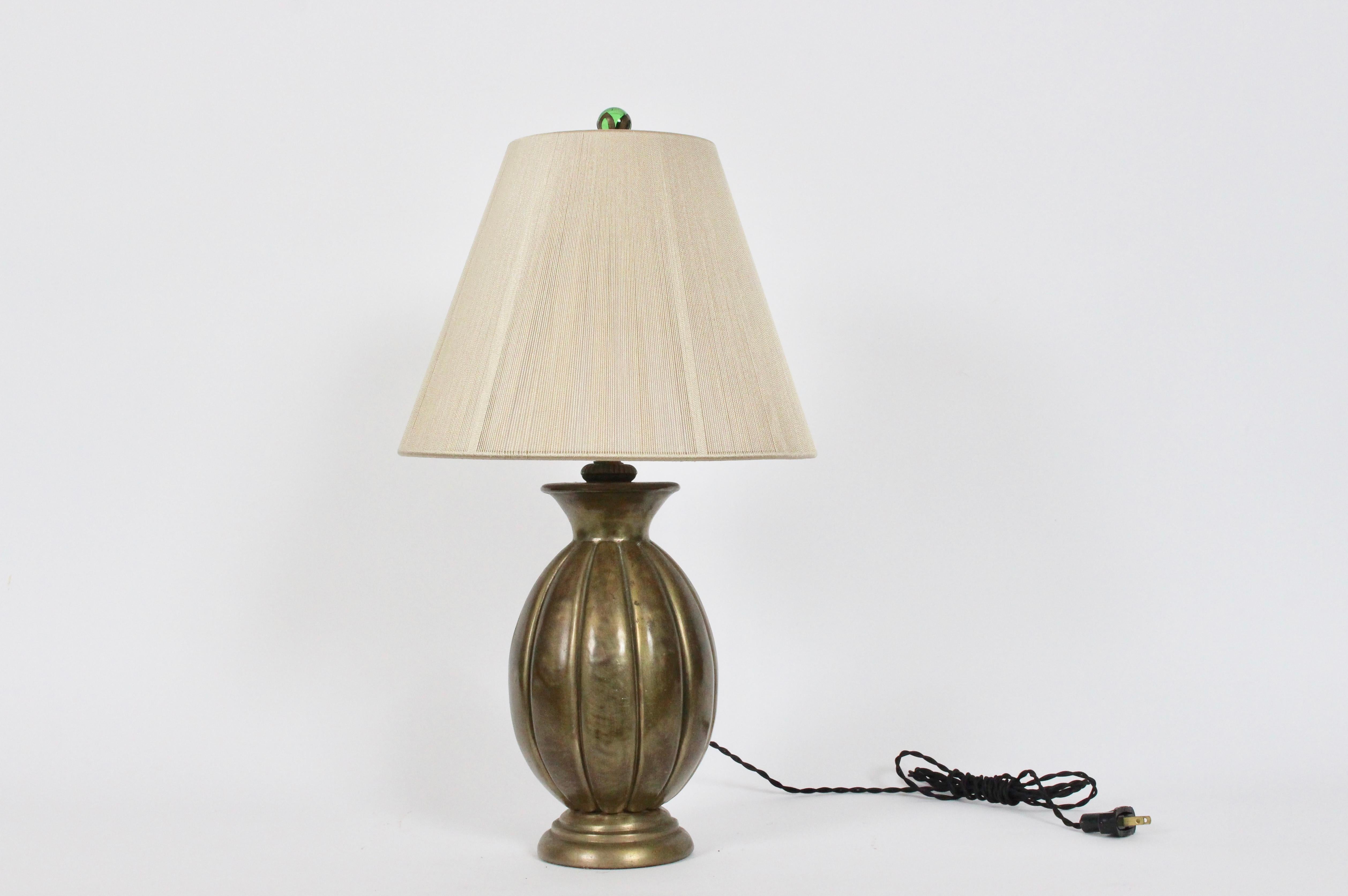 Smaller Just Andersen style all bronze bedside table lamp, 1940's. Heavy cast Bronze bottle form with smooth ribbed detail and nice vintage patina on circular base. With original translucent Green Glass ball Finial. Lampshade shown for display only