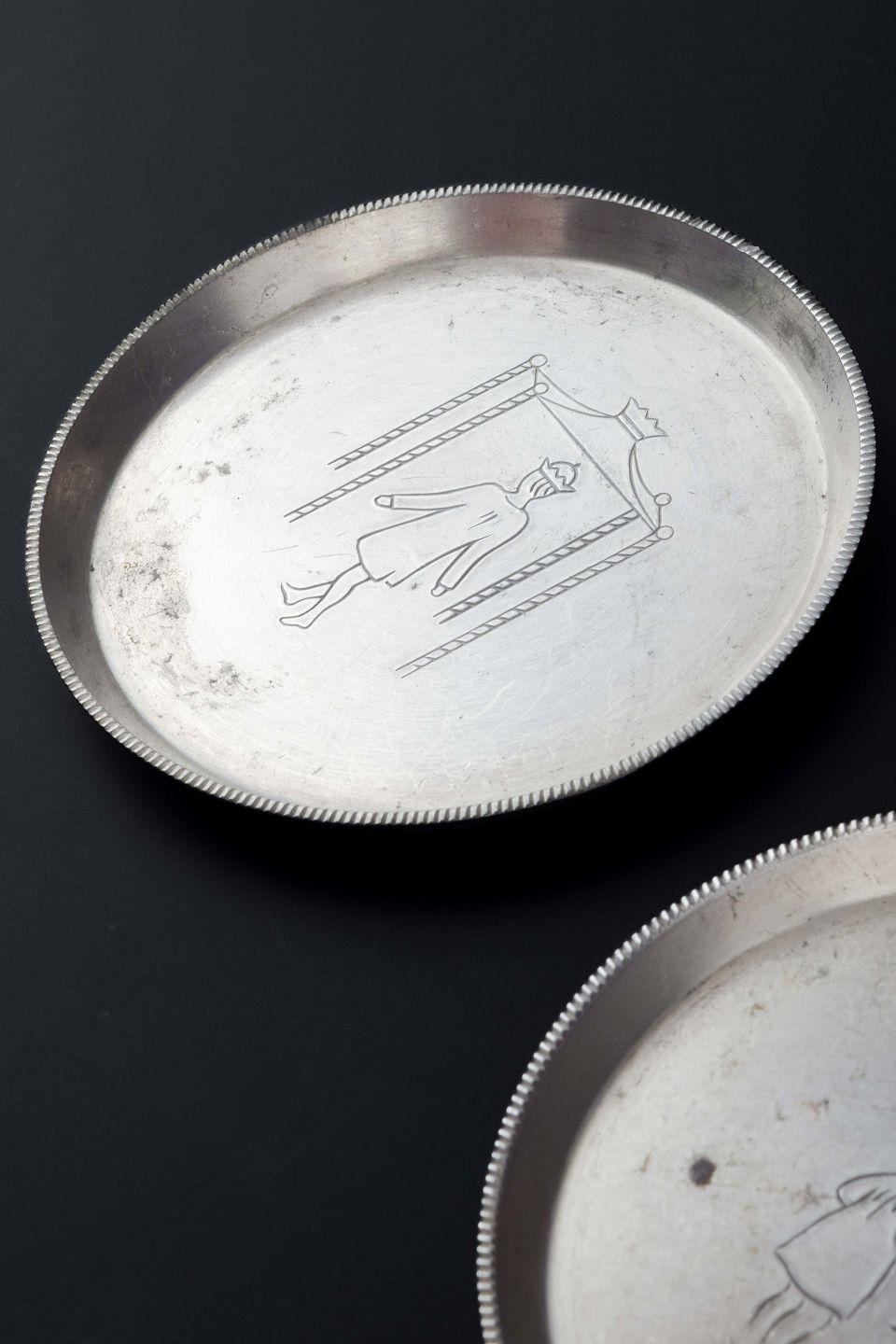 Just Andersen, three bottle coasters, model 2620.
Three small round bottle coasters in pewter, engraved with scenes from Hans Christian Andersen’s fairy tales, including Ole Lukøje (The Sandman) and The Emperor’s New Clothes.
Stamped: Just / Denmark