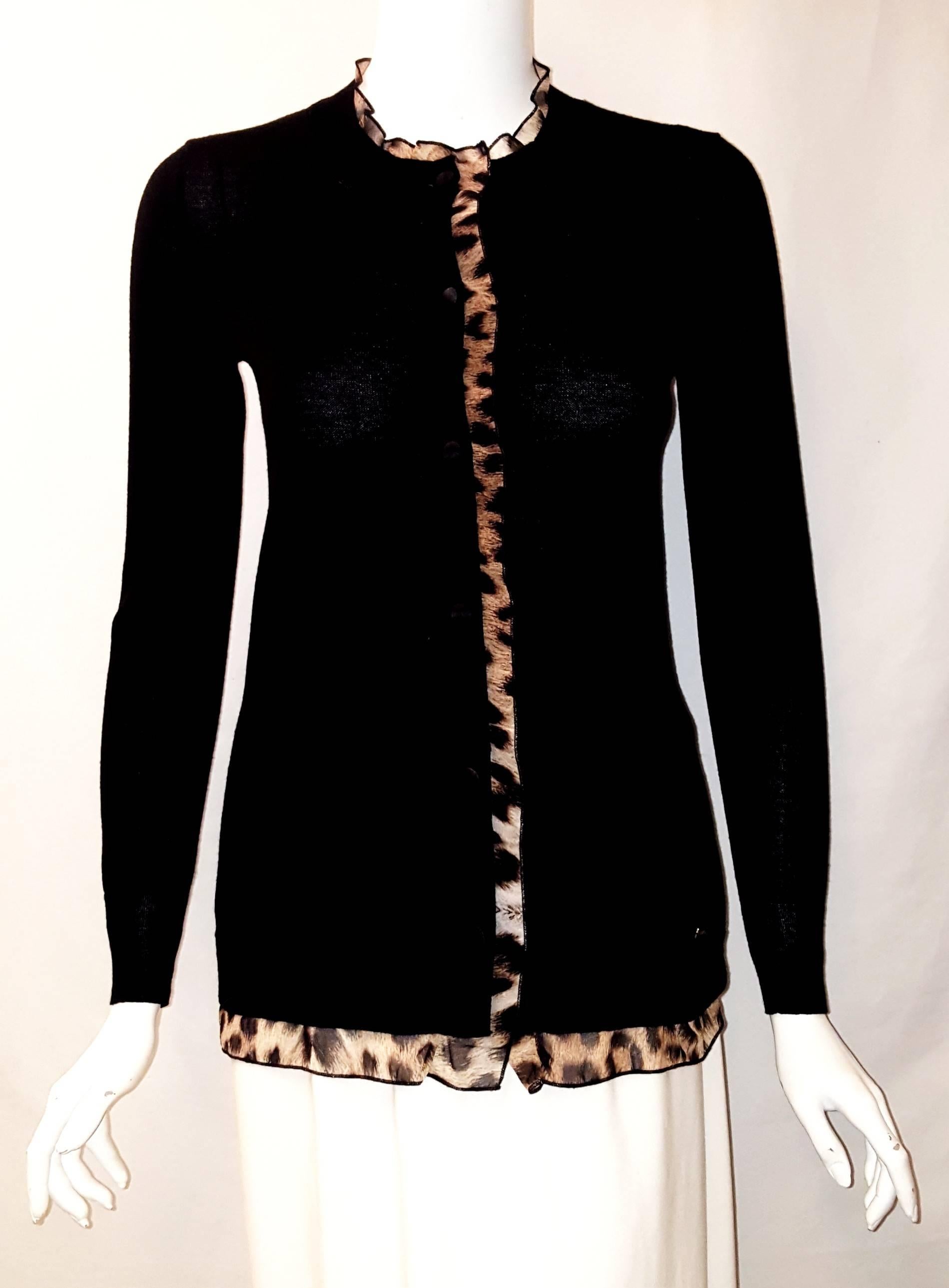 Just Cavalli black knit wool cardigan with long sleeves is ribbed at wrist and has leopard viscose print ruffles around neckline, front closure and hemline enhancing its appearance. For closure there are 6 satin covered buttons. Small gold tone Just