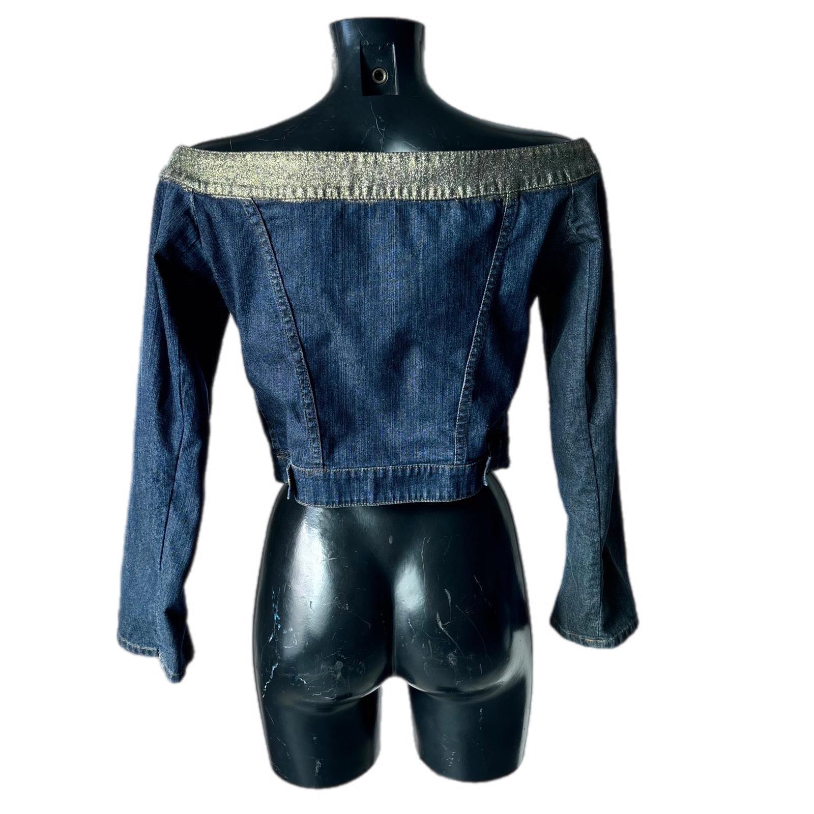 Chaqueta vaquera icónica de Just Cavalli de principios de la década de 2000, una pieza de culto del estilo Y2K Cavalli. Confeccionado en tejido vaquero azul 100% algodón, presenta un exclusivo corte vaquero off shoulder que deja los hombros al