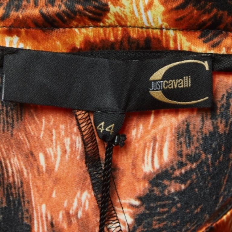 Déjate seducir por el feroz encanto de la falda midi Just Cavalli. Confeccionada en lujoso satén, su vibrante tono naranja se fusiona a la perfección con el atrevido estampado animal negro, creando una pieza cautivadora. La silueta acampanada fluye