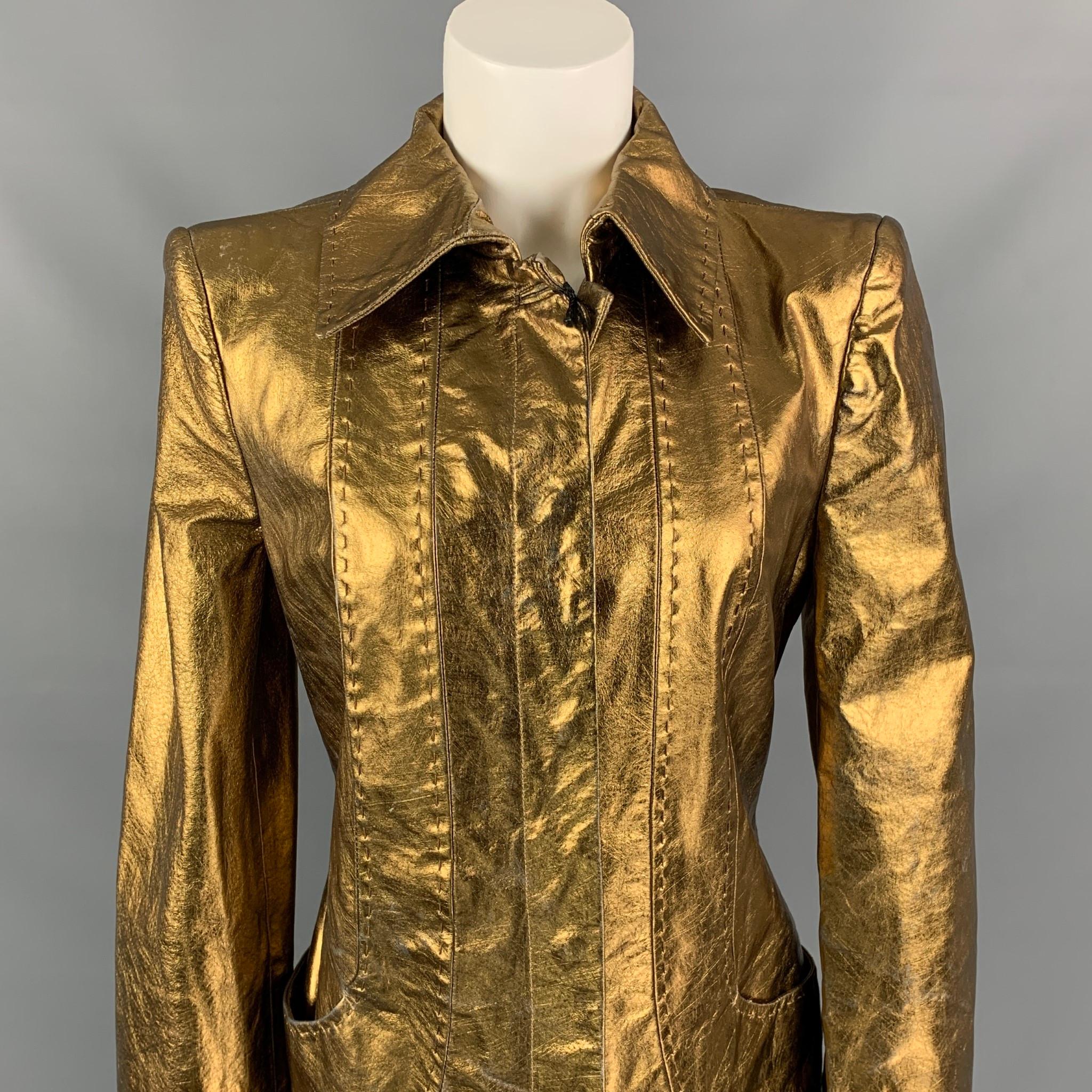 Il cappotto di Just Cavalli è in pelle metallizzata color bronzo e presenta una fodera completa, cuciture in alto, tasche a fessura, colletto ampio, cinturino posteriore e  chiusura con bottone a pressione nascosto. Include etichette. Prodotto in