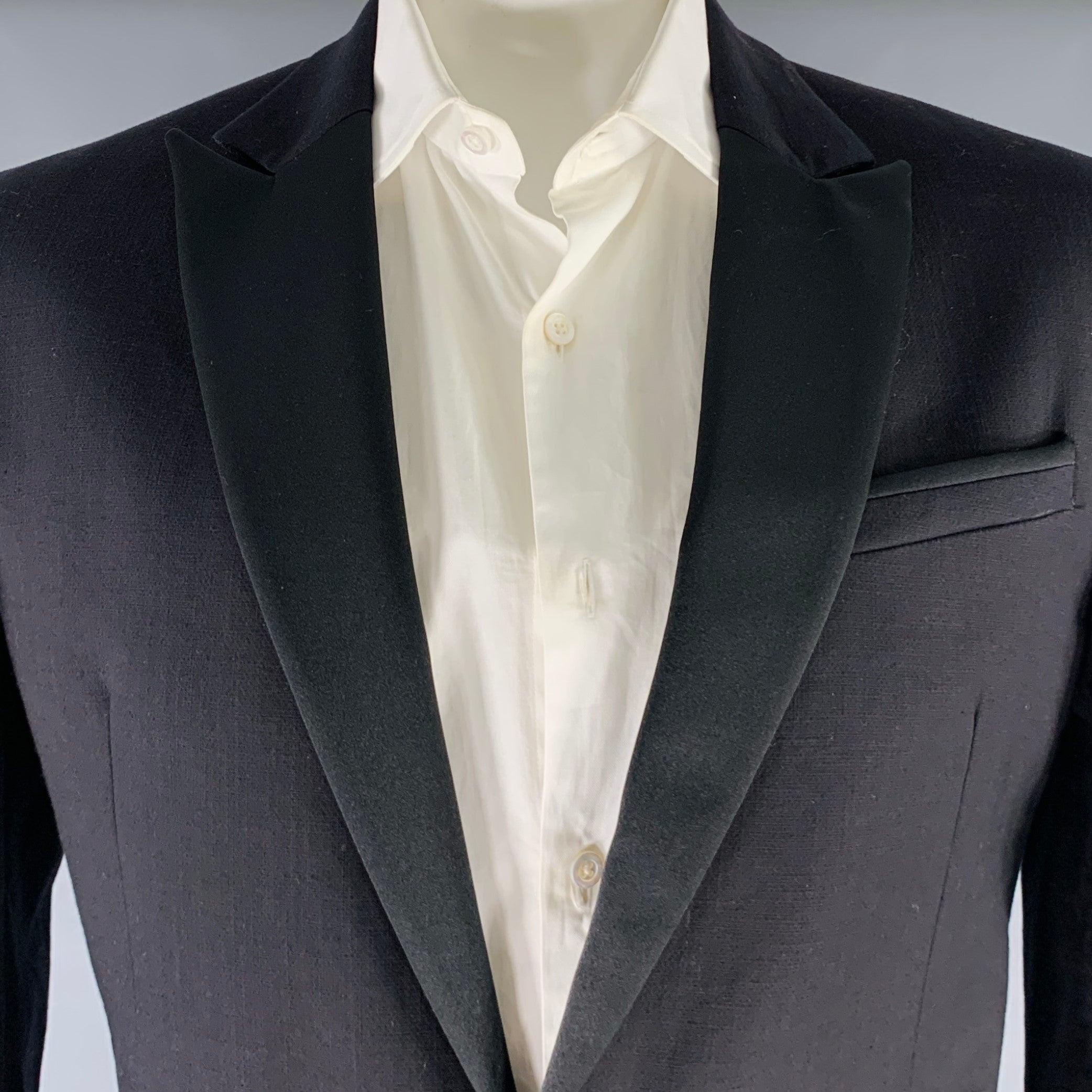 JUST CAVALLI tuxedo
in a black cotton blend with a full liner and includes a single breasted, single button sport coat with a peak lapel and matching flat front trousers.Very Good Pre-Owned Condition. Moderate signs of wear, as is. 

Marked:   56