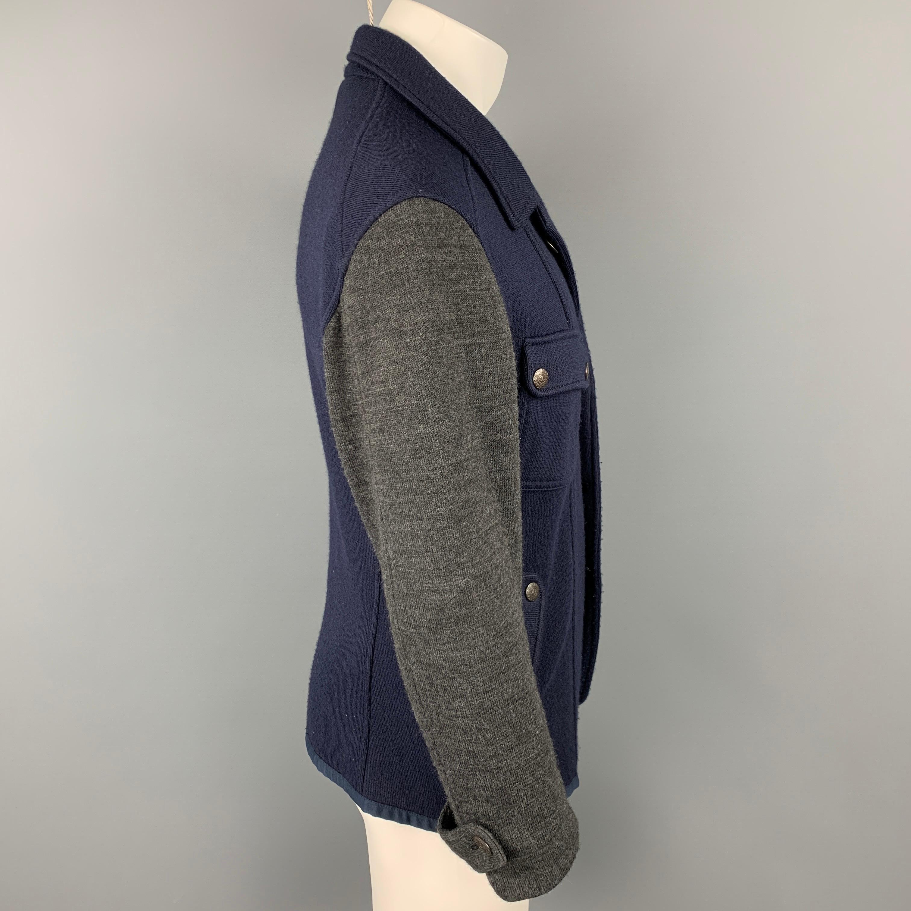 JUST CAVALLI jacket comes in a navy & grey color block knitted material featuring spread collar, flap pockets, and a metal button closure. 

Very Good Pre-Owned Condition.
Marked: 52

Measurements:

Shoulder: 20.5 in.
Chest: 44 in.
Sleeve: 23.5