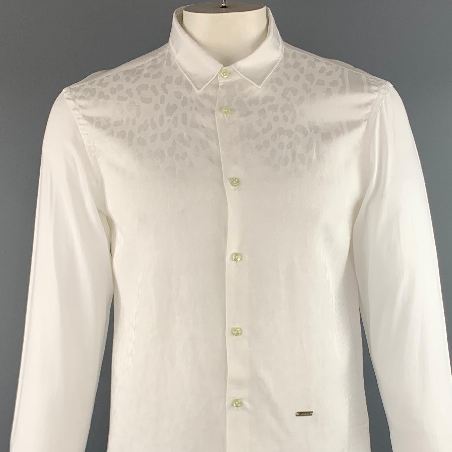 JUST CAVALLI long sleeve shirt comes in a white on white animal print cotton / viscose featuring a button up style, tint green buttons, and a spread collar. Made in Romania.

Excellent Pre-Owned Condition.
Marked: 52

Measurements:

Shoulder: 17.5